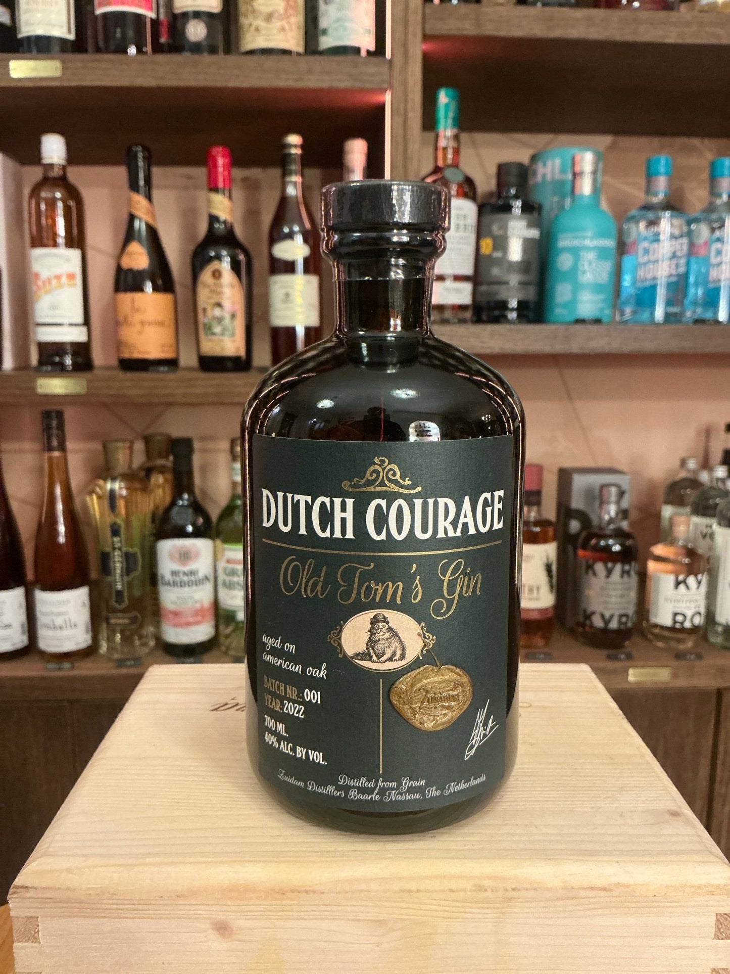 Dutch Courage Old Tom’s Gin in a dark, artisan glass bottle with gold and cream botanical design, premium small batch.