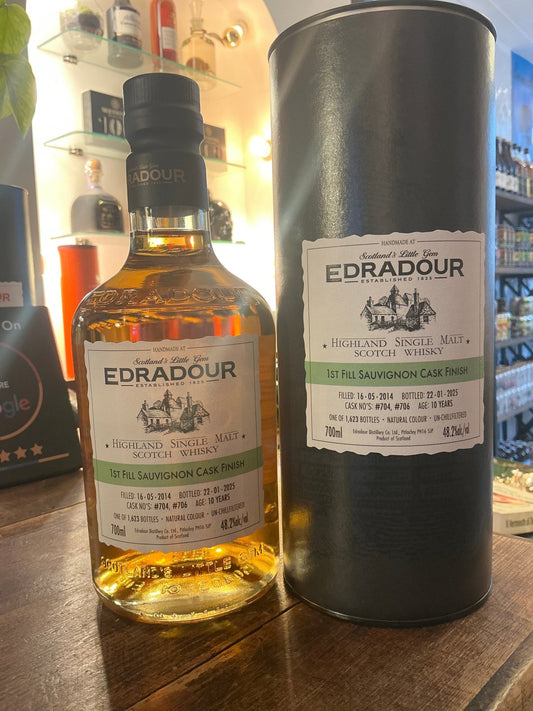 Edradour 2014 Sauvignon single malt whisky bottle with amber liquid and black cap, next to matte black cylindrical box with.