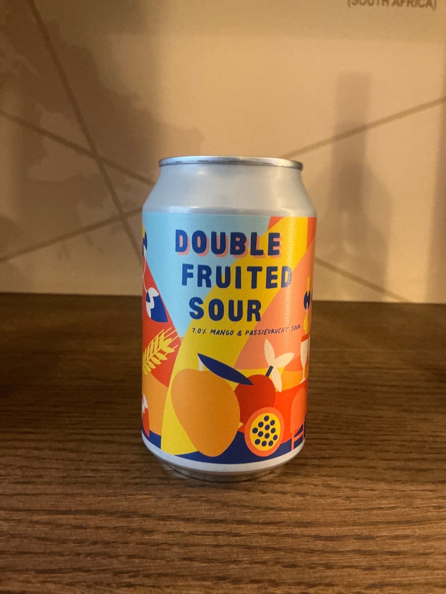 Colorful aluminum can with peach, passion fruit, and orange graphics, labeled "Double Fruited Sour" in bold blue letters on.