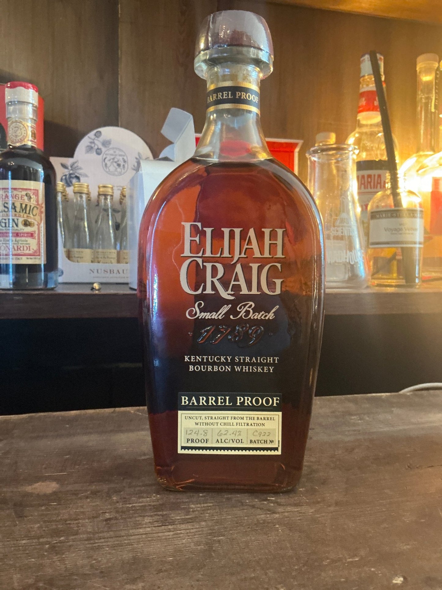 Elijah Craig Barrel Proof Bourbon bottle with rich amber liquid, premium small batch Kentucky bourbon, aged and distilled,.