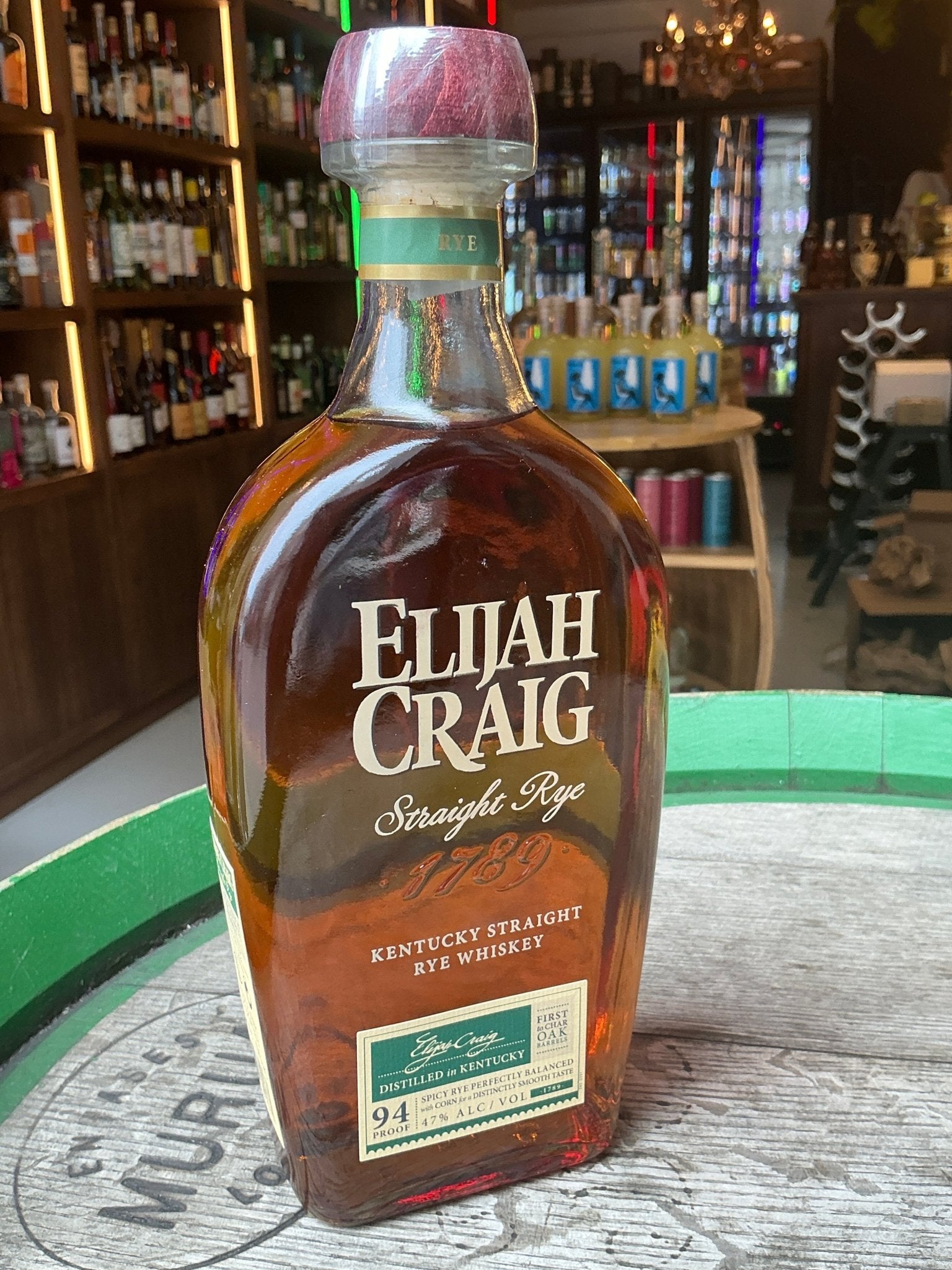 Elijah Craig small batch rye whiskey bottle with amber aged spirit, premium Kentucky distilled bourbon on wooden barrel.