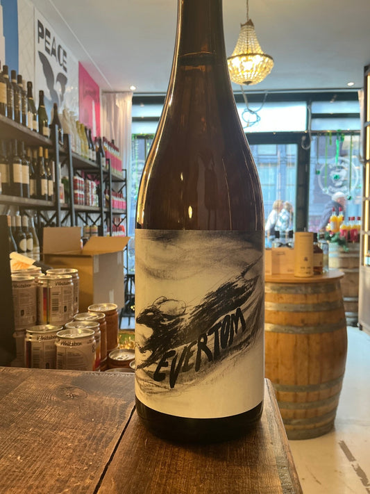 EverTom premium artisan cider bottle with minimalist black-and-white label featuring botanical design, displayed in rustic.