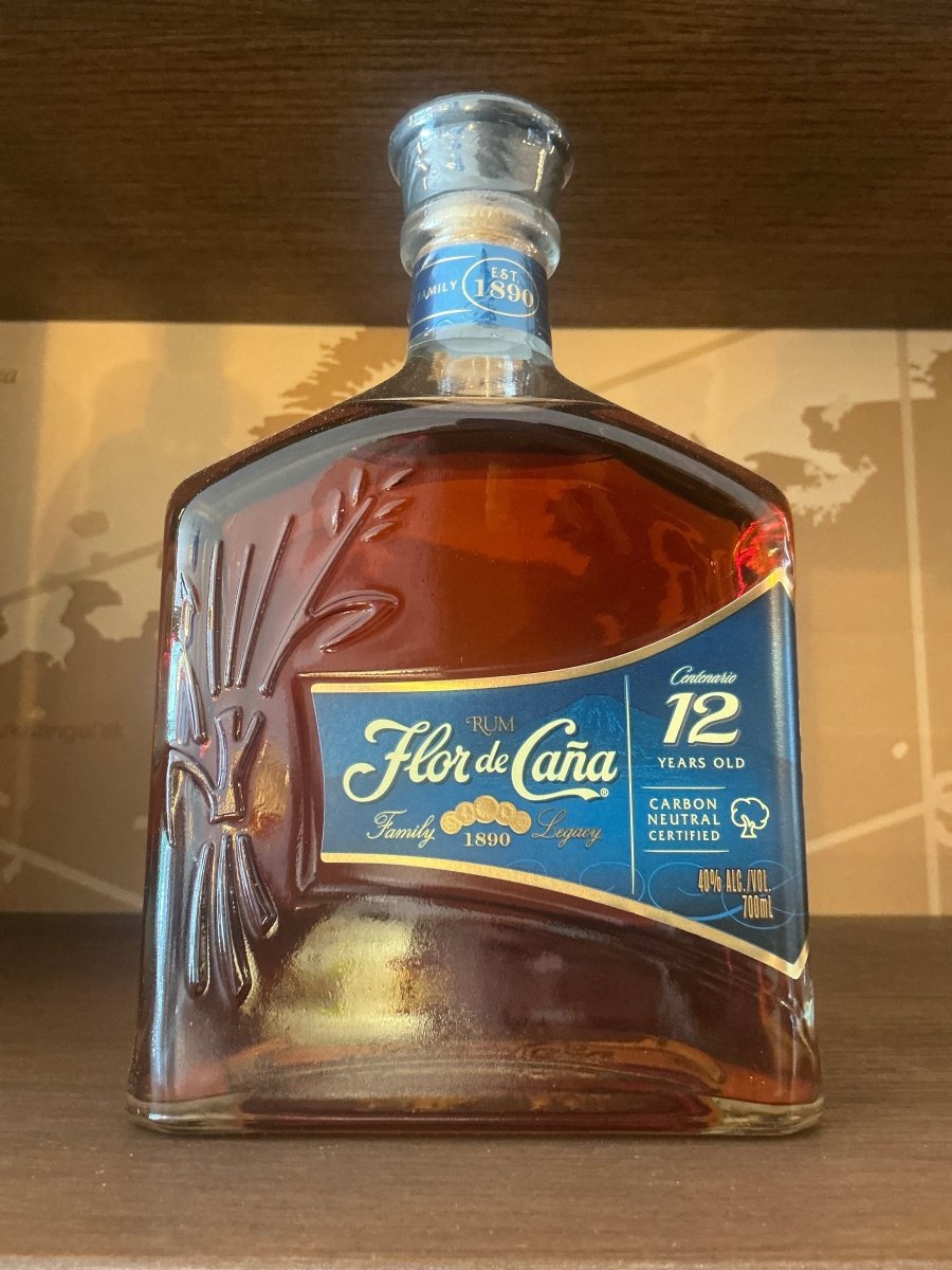 Flor de Caña 12 Year Centenario rum 700ml decanter-style bottle with navy blue label — single estate Nicaraguan rum, carbon neutral certified, est. 1890, 40% ABV