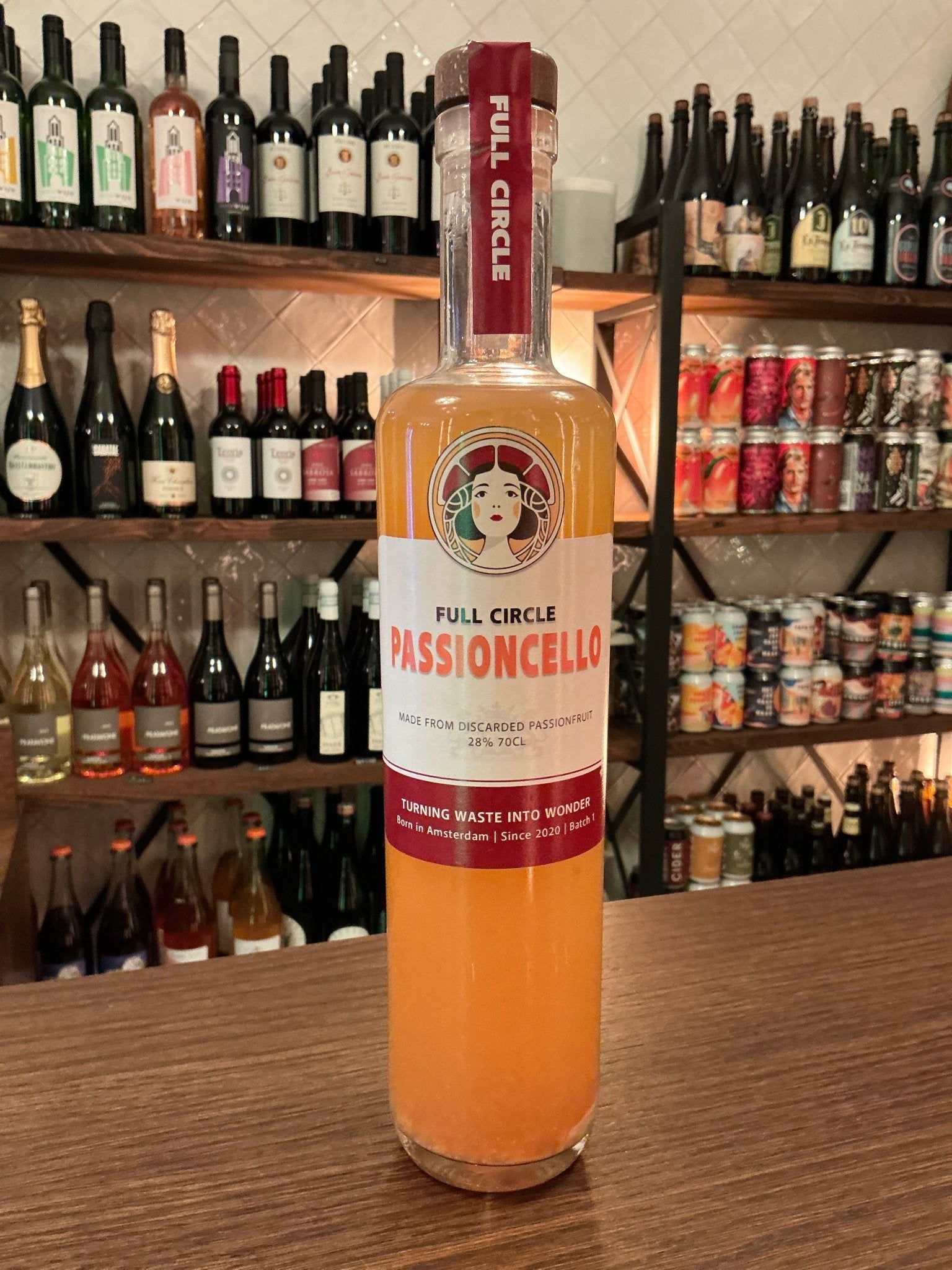 Tall slender bottle of Full Circle Passioncelli passionfruit liqueur with orange liquid, labeled artisan Dutch specialty.