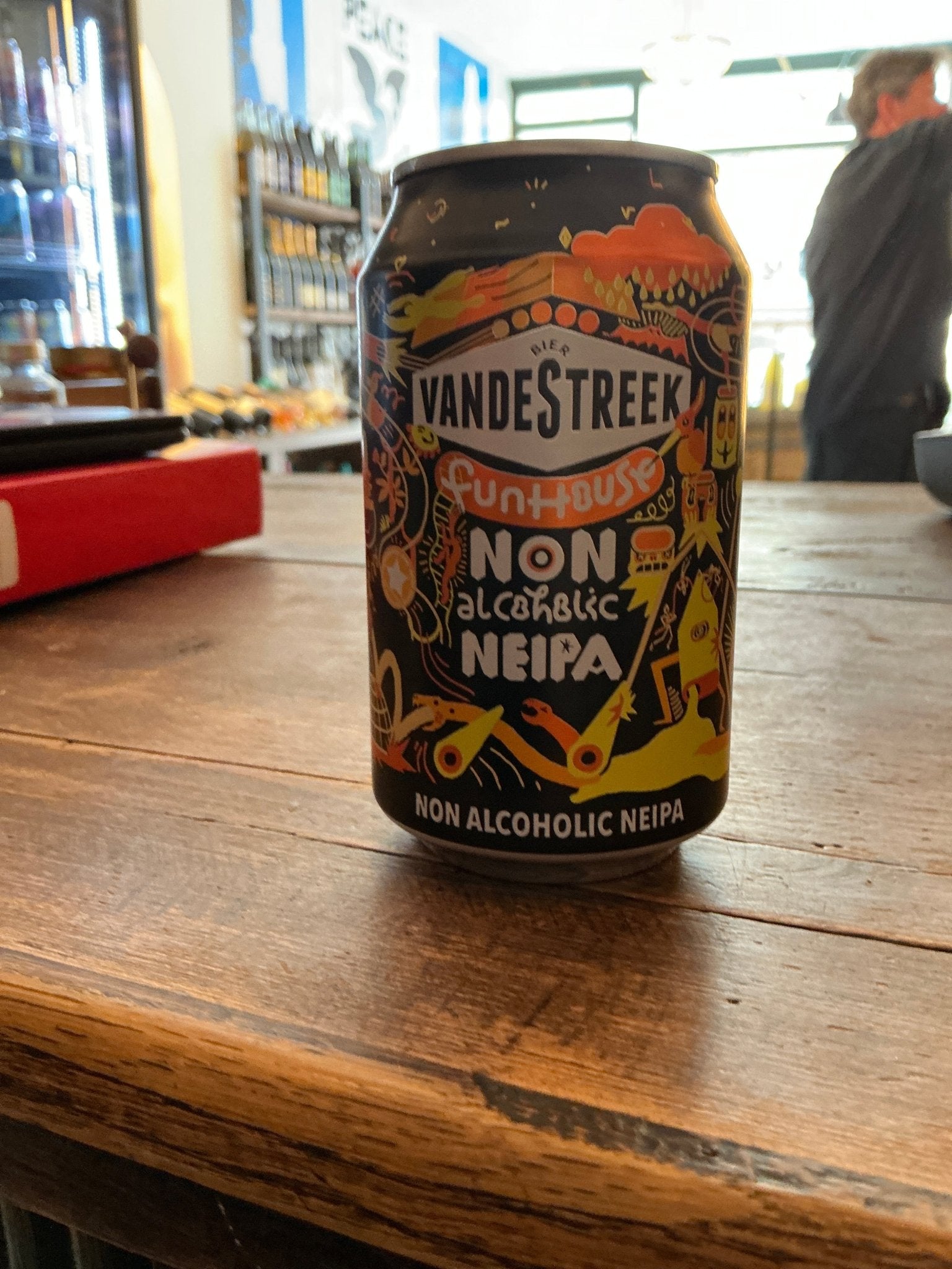Vandestreek FunHouse Non-Alcoholic NEIPA craft beer can with colorful botanical and spiced design on wooden table, premium.