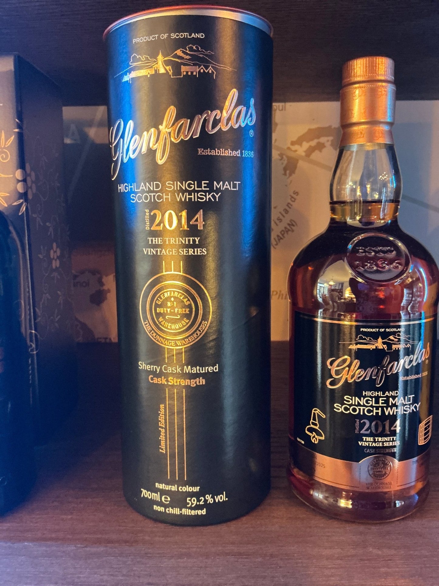 Glenfarclas 2014 Trinity Vintage Series single malt whisky bottle and black cylindrical box with gold lettering, premium.