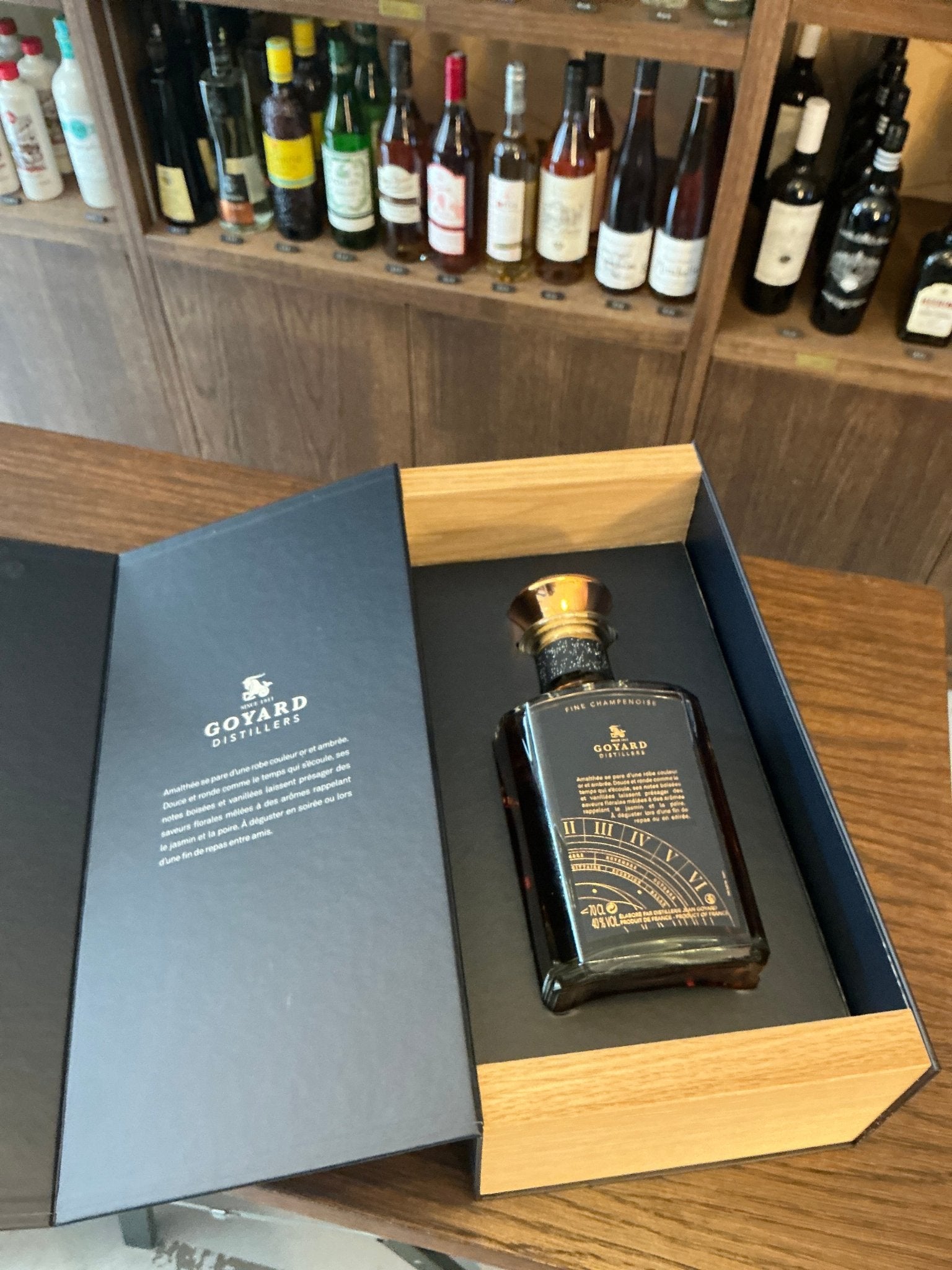 Goyard Amalthee Fine Champenoise XO brandy in a premium dark bottle with gold detailing inside a luxury wooden gift box,.