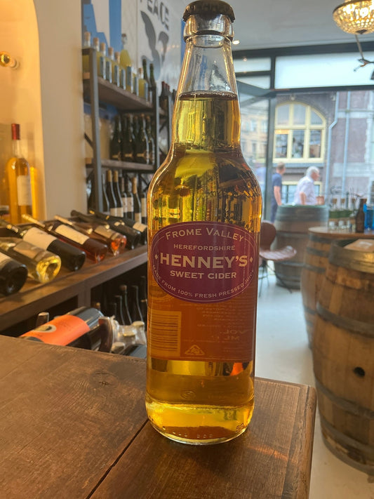 Henney’s Frome Valley Dry Cider bottle with golden amber liquid, premium artisan small batch cider in a glass bottle with a.