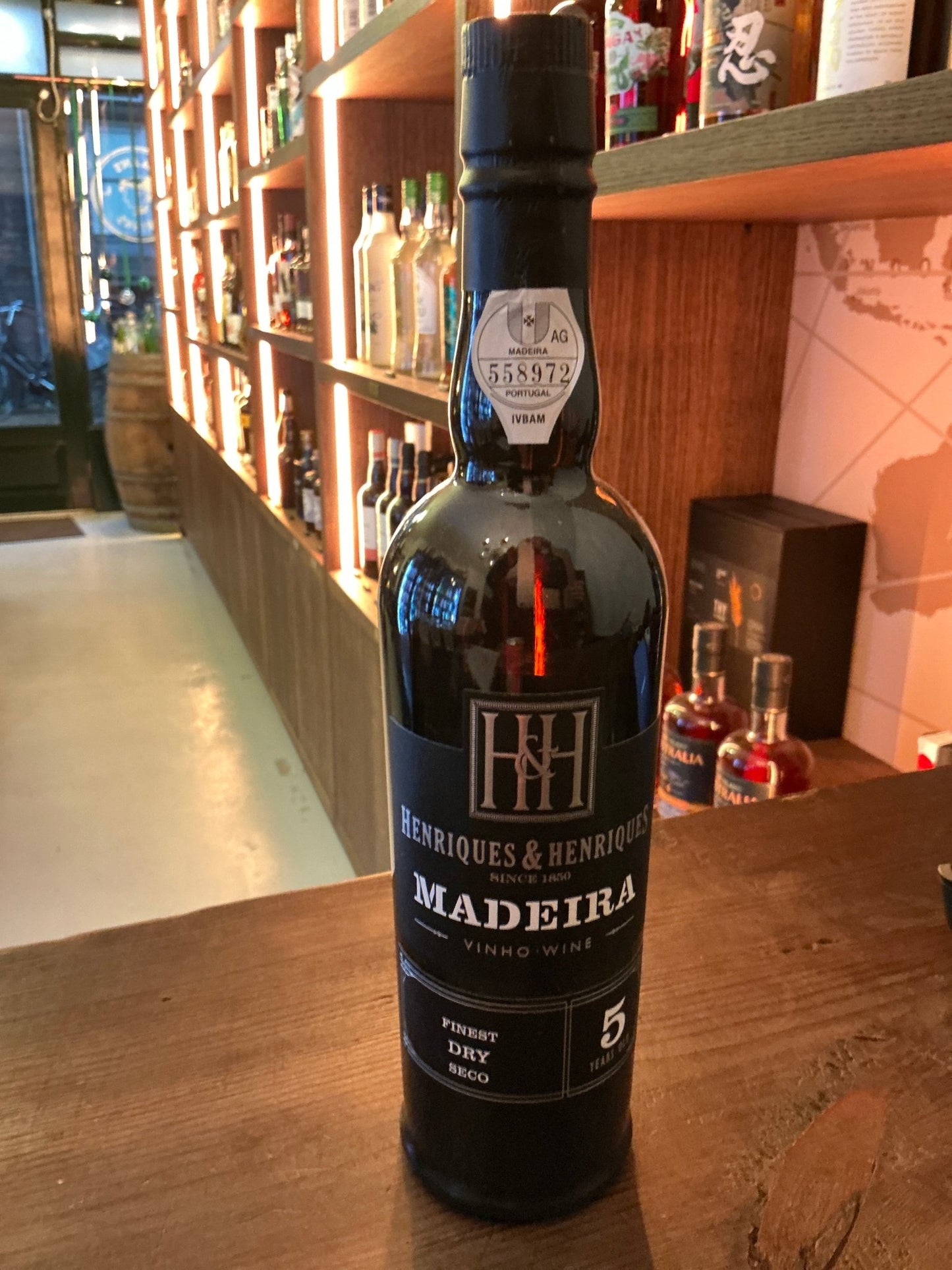 Henriques & Henriques 5 Yr Finest Dry Madeira wine bottle with black label, premium aged fortified specialty spirit on.