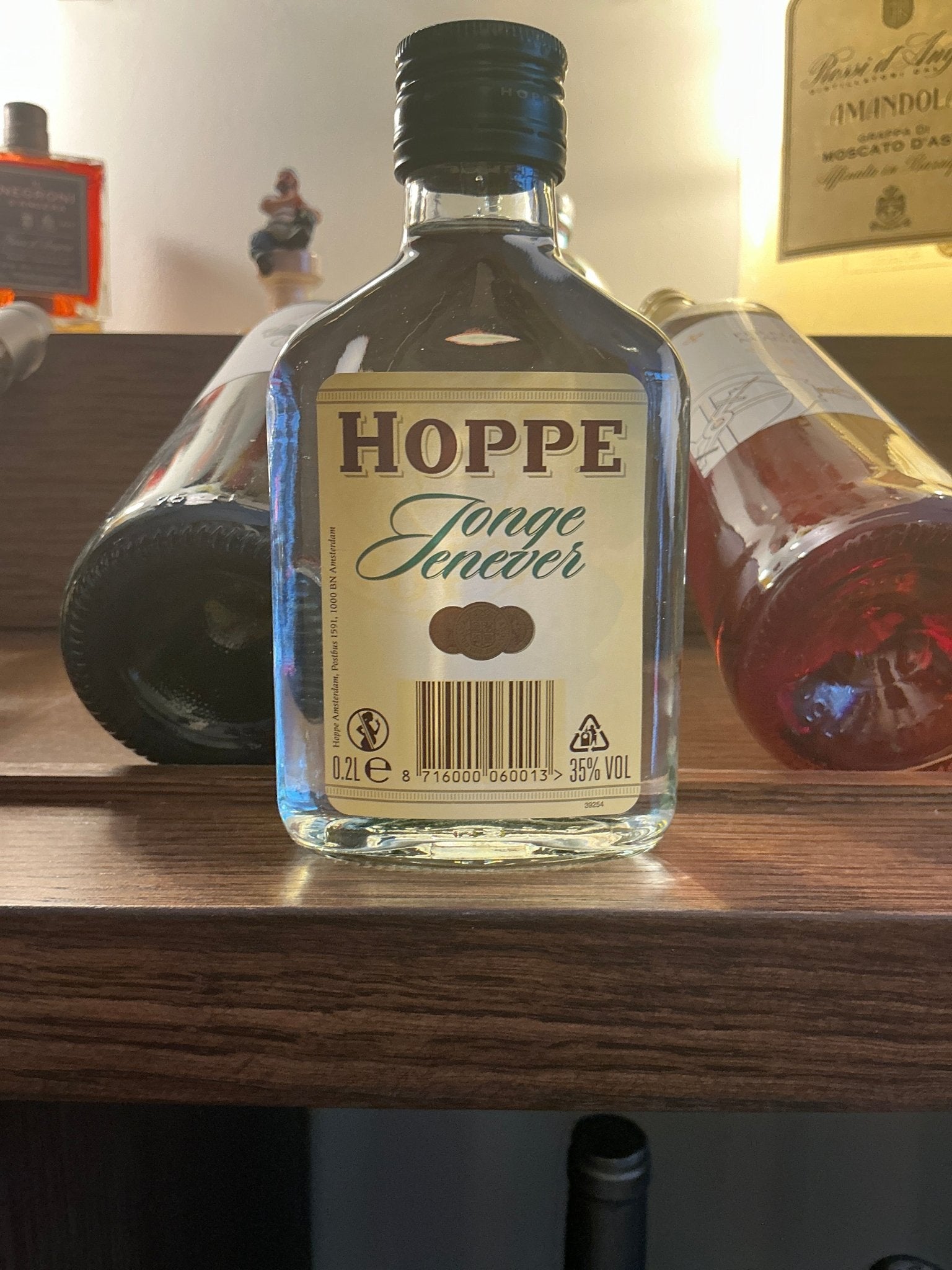 Hoppe Jonge Genever Dutch artisan bottle with clear glass, black cap, premium distilled botanical spirit.