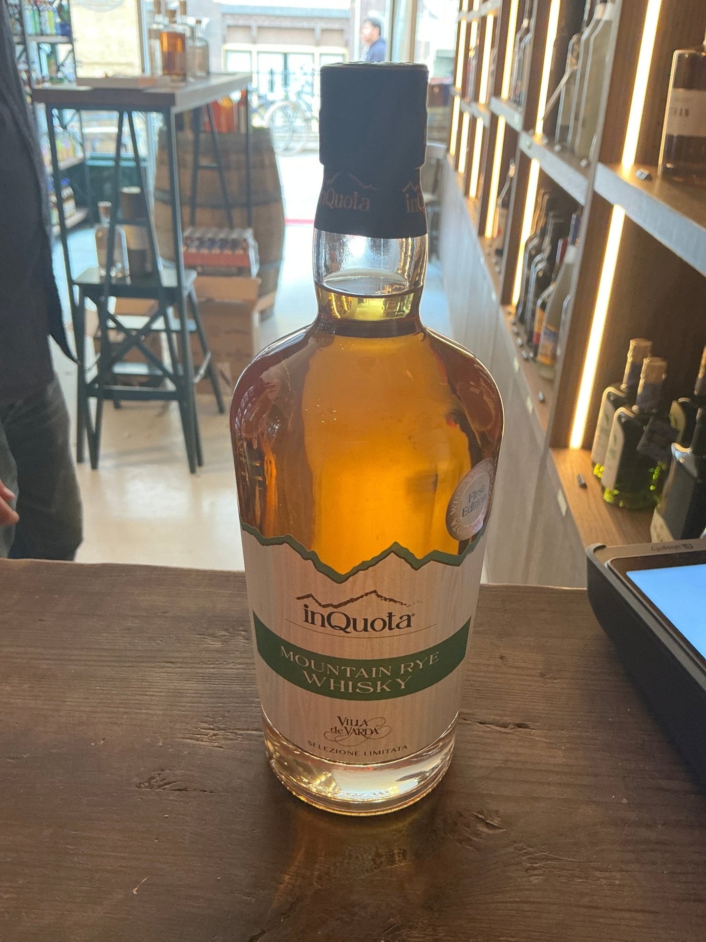 Inquota Mountain Rye Whisky bottle with amber liquid, premium small-batch artisan spirit, aged and distilled rye whiskey,.