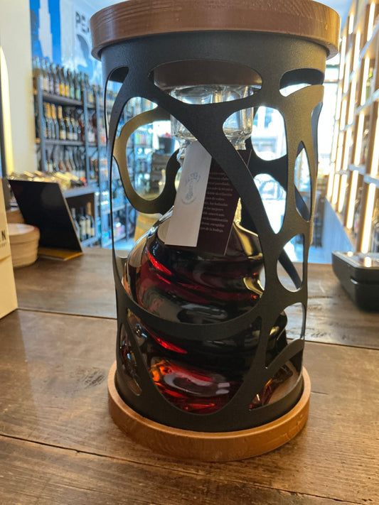 Premium Jaime I Brandy bottle encased in ornate black metal cage with wooden top and base, showcasing rich amber aged.