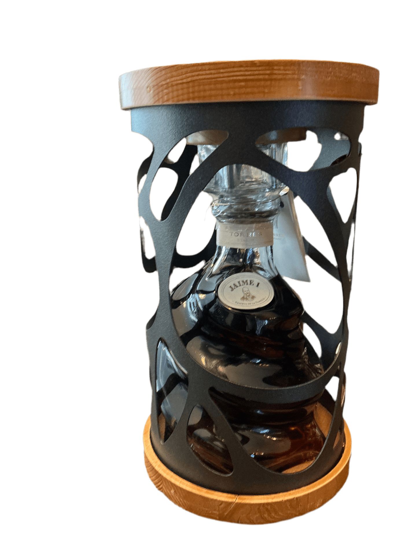 Premium Jaime I Brandy in a clear glass decanter with dark amber liquid, housed in an artisan black metal and wood display.