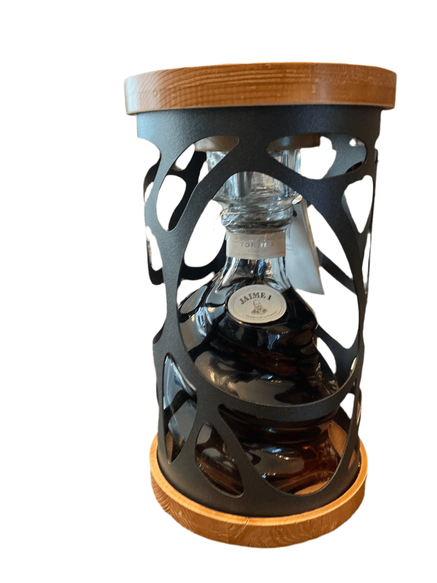 Premium Jaime I Brandy in a clear glass decanter with dark amber liquid, housed in an artisan black metal and wood display.