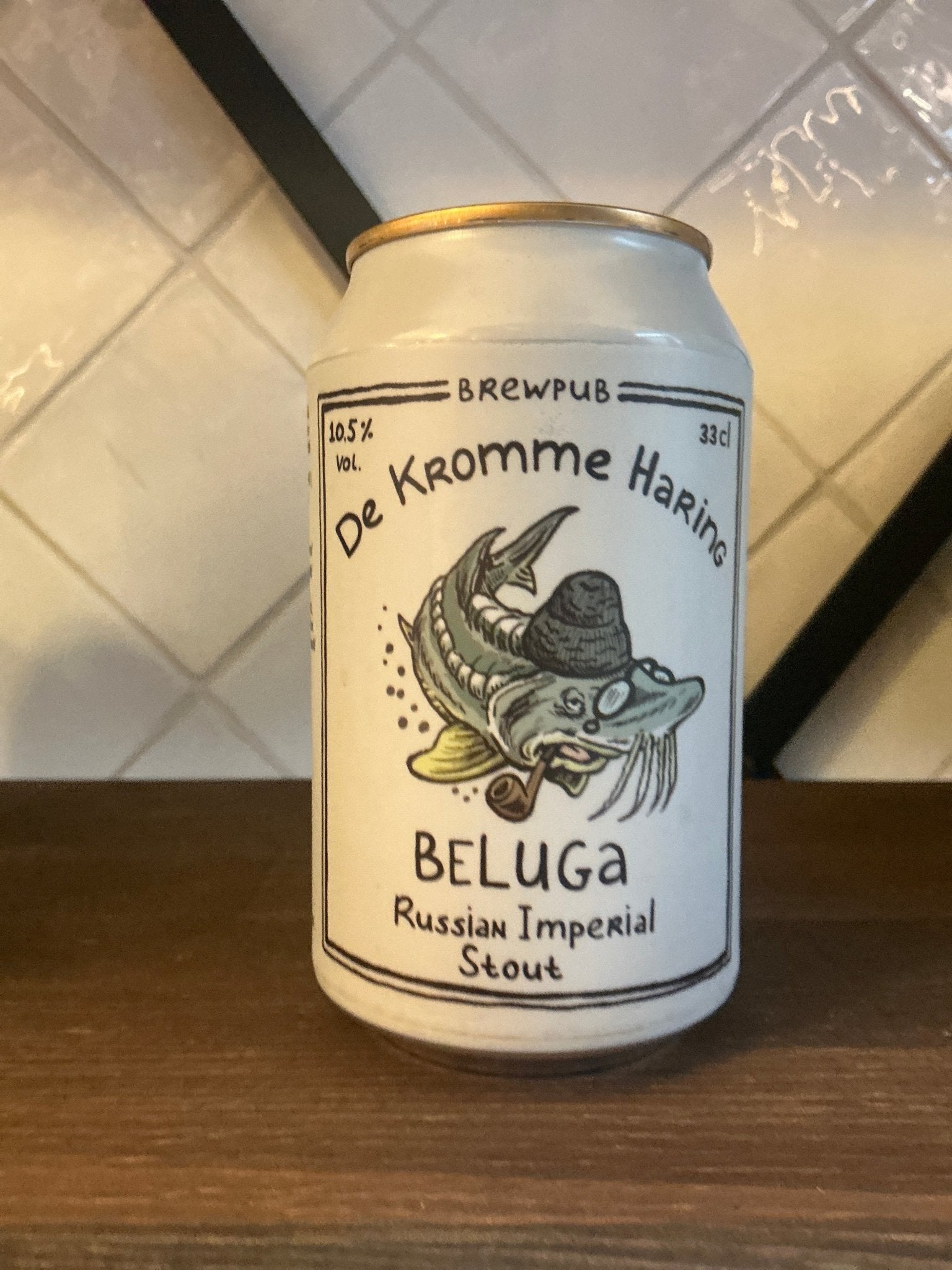 White can with black and yellow illustration of a fish, labeled De Kromme Haring Beluga Russian Imperial Stout craft beer,.
