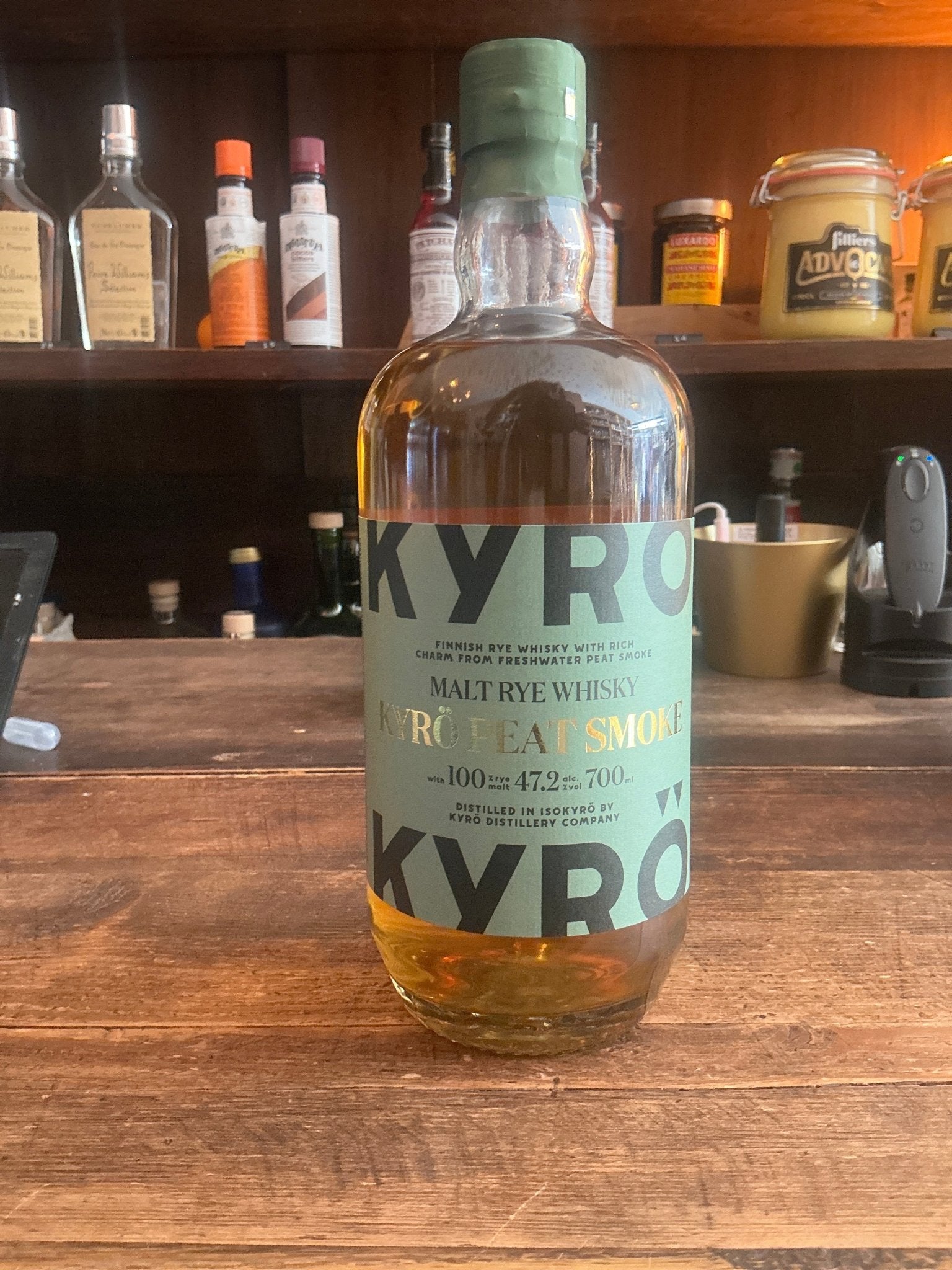 Kyro Peat Smoke Rye Whisky bottle with light amber liquid, green label highlighting smoky, peated rye spirit, premium.