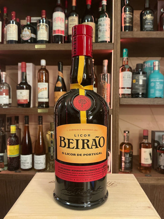 Dark glass bottle of Licor Beirao Portuguese herbal liqueur with red and cream label, premium spiced artisan spirit.