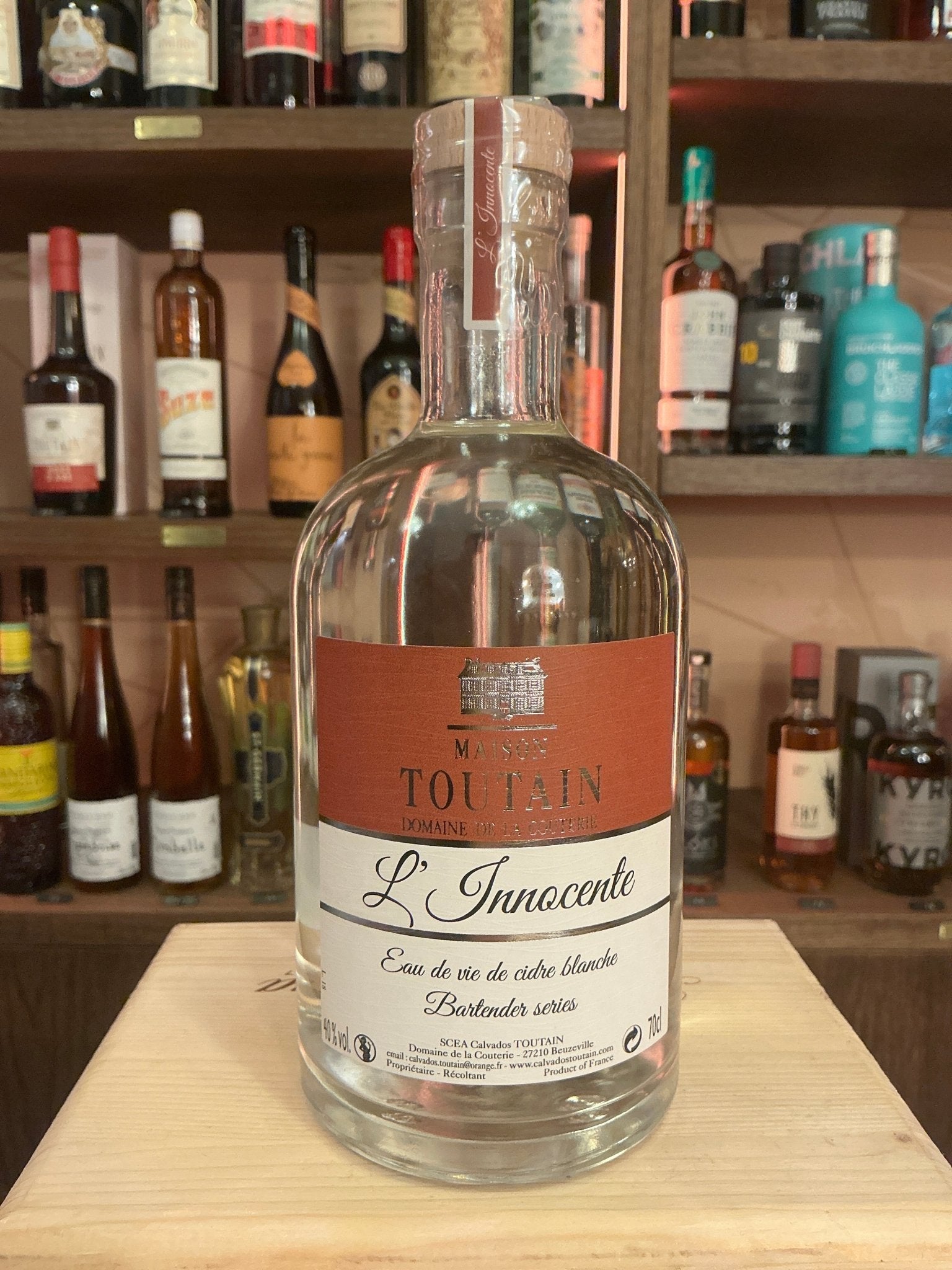L’innocente Eaux de Vie De Cidre Blanche clear glass bottle with copper label, premium distilled artisanal brandy, small.