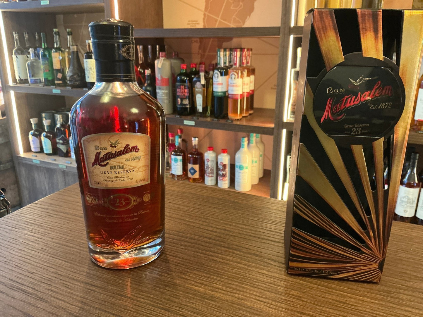 Matusalem 23 years Gran Reserva premium aged rum bottle with rich amber color and elegant label on wood surface next to.
