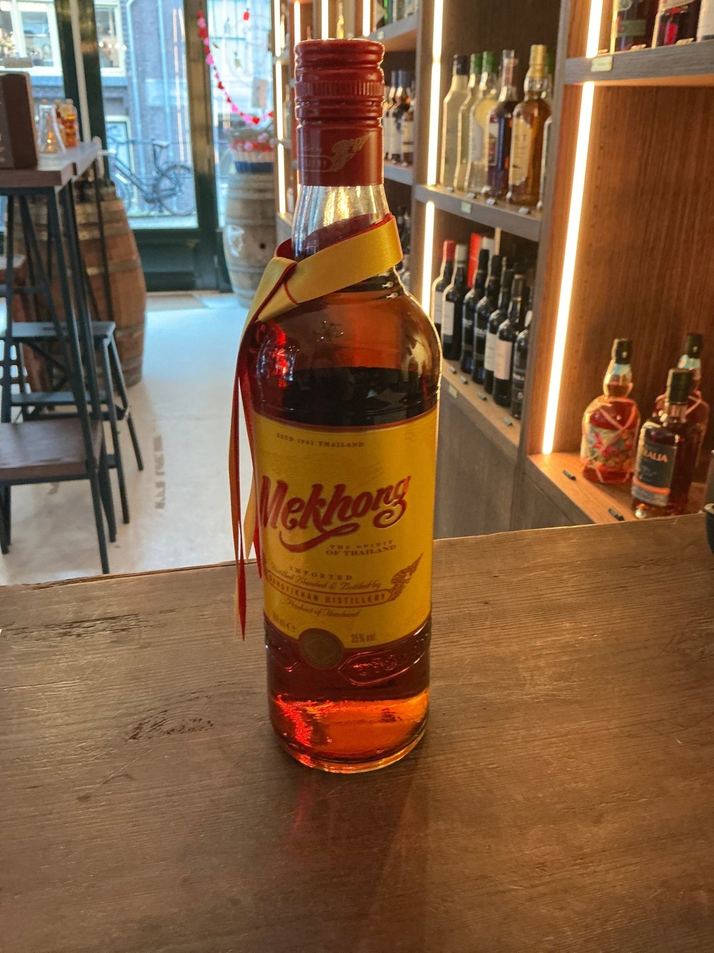 Mekhong Thai Spirit golden rum bottle with red cap, premium artisan sugarcane distilled rum, small batch specialty spirits.