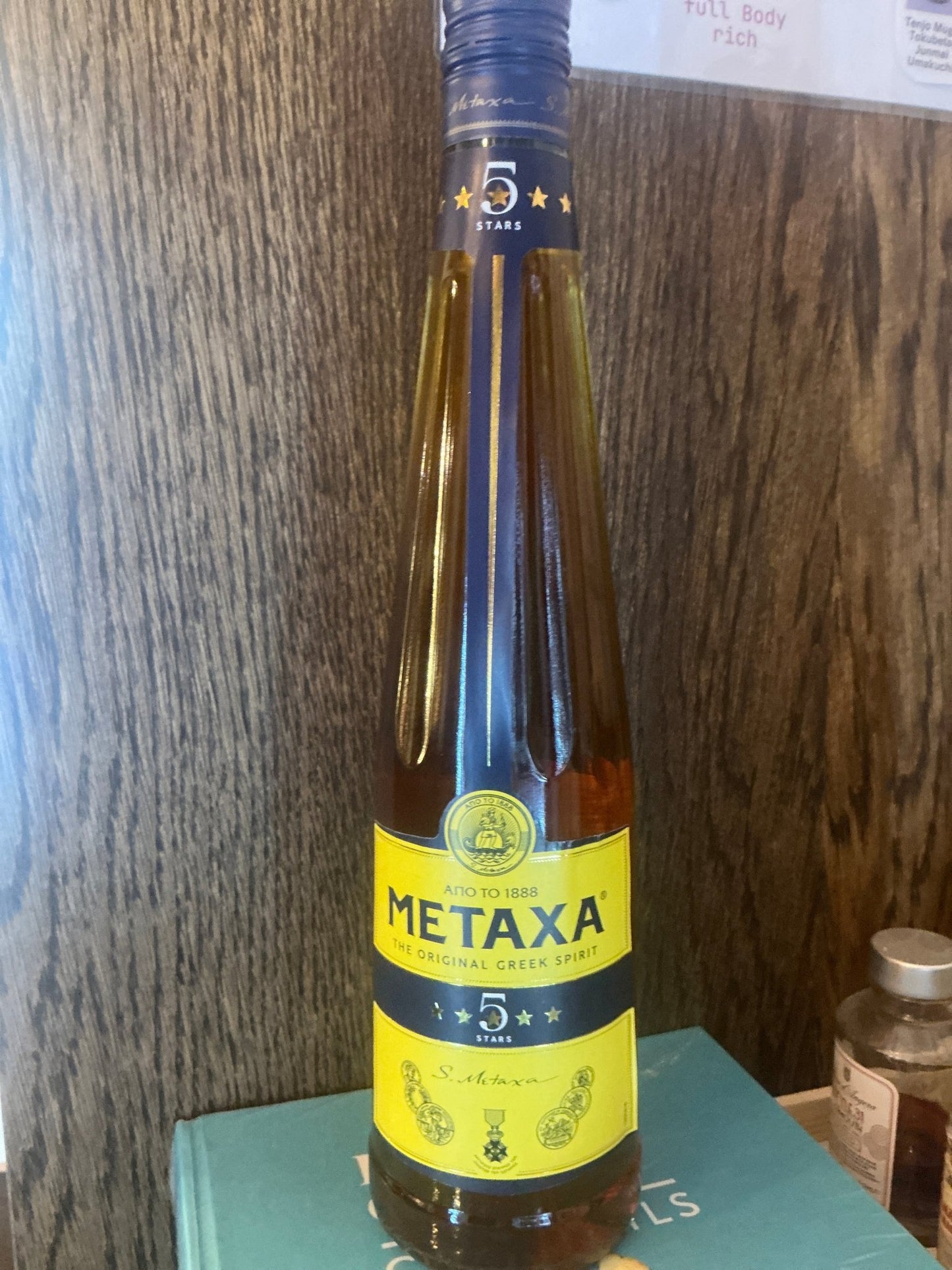 Tall Metaxa 5 Star Greek Brandy bottle with deep amber liquid, labeled premium artisanal craft spirit, limited edition gift, .
