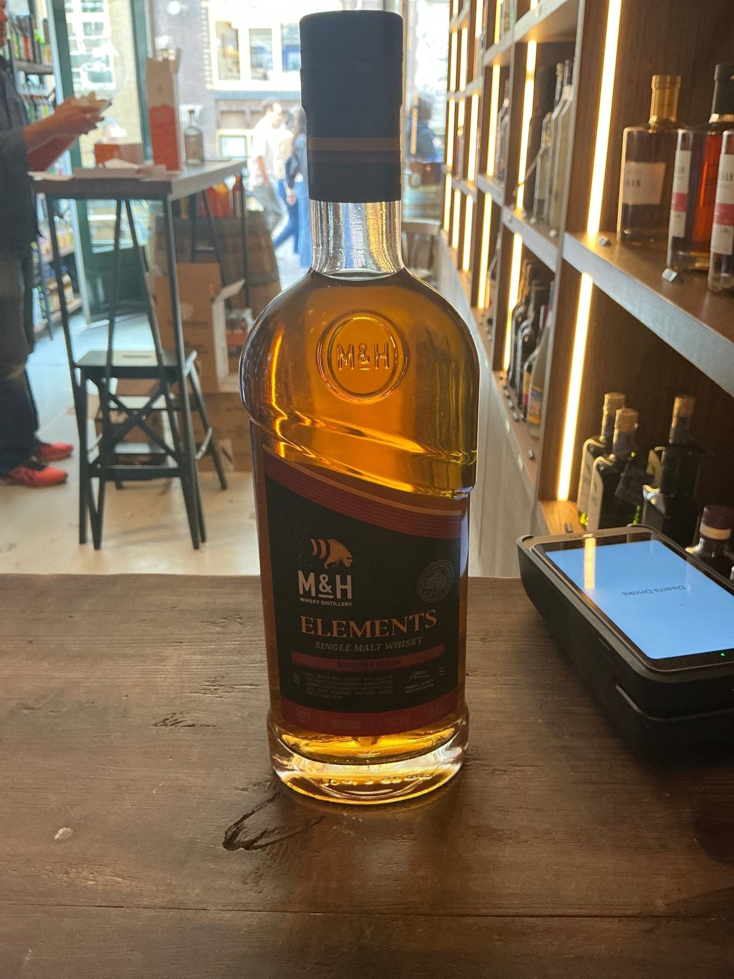 Milk and Honey Elements Single Malt whisky bottle with amber aged spirit, black label, premium small batch artisan Dutch.