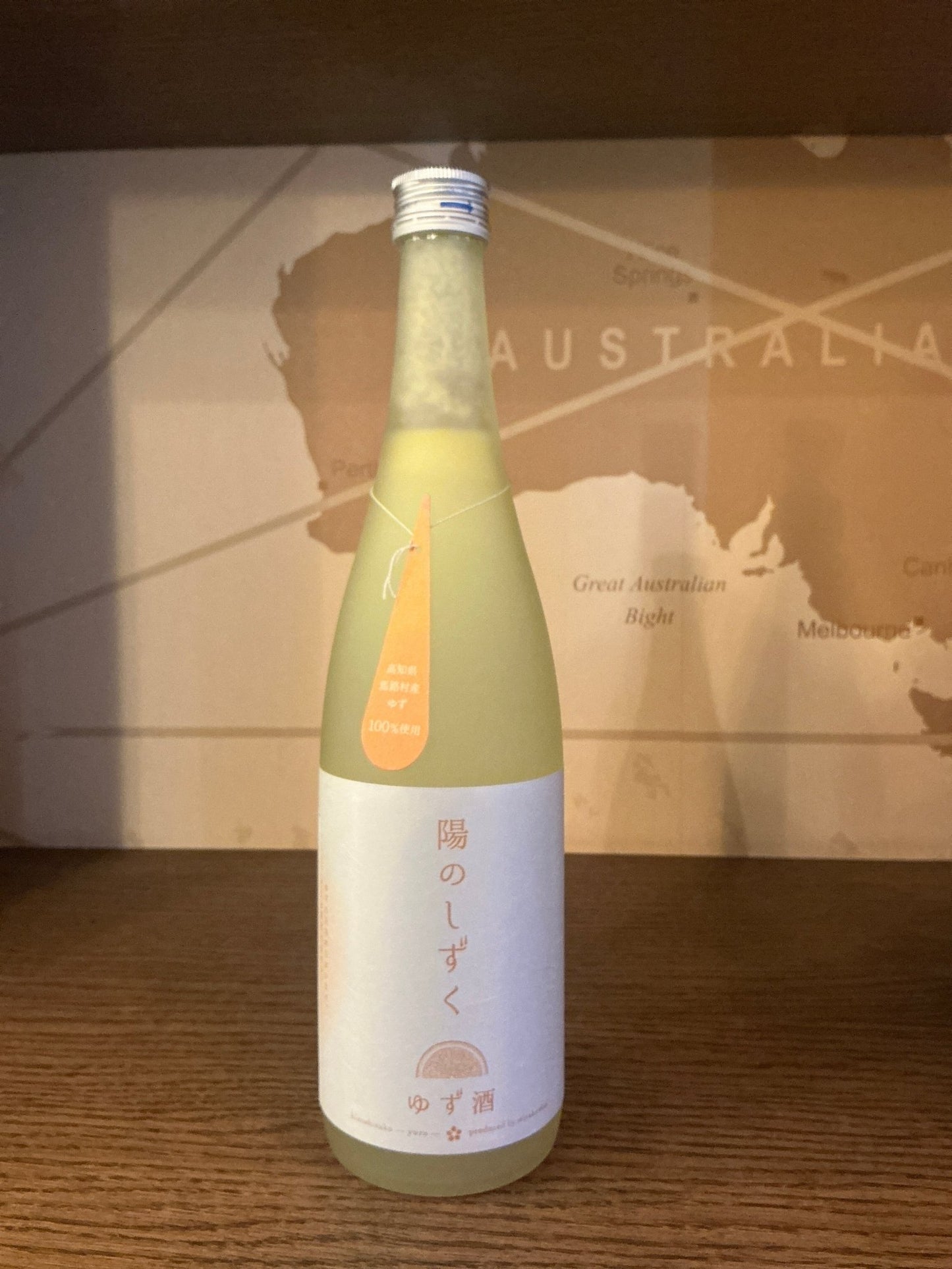 Premium artisanal Miyakanbai Yuzu Sake in tall frosted glass bottle with Japanese label, limited edition Dutch craft spirit.