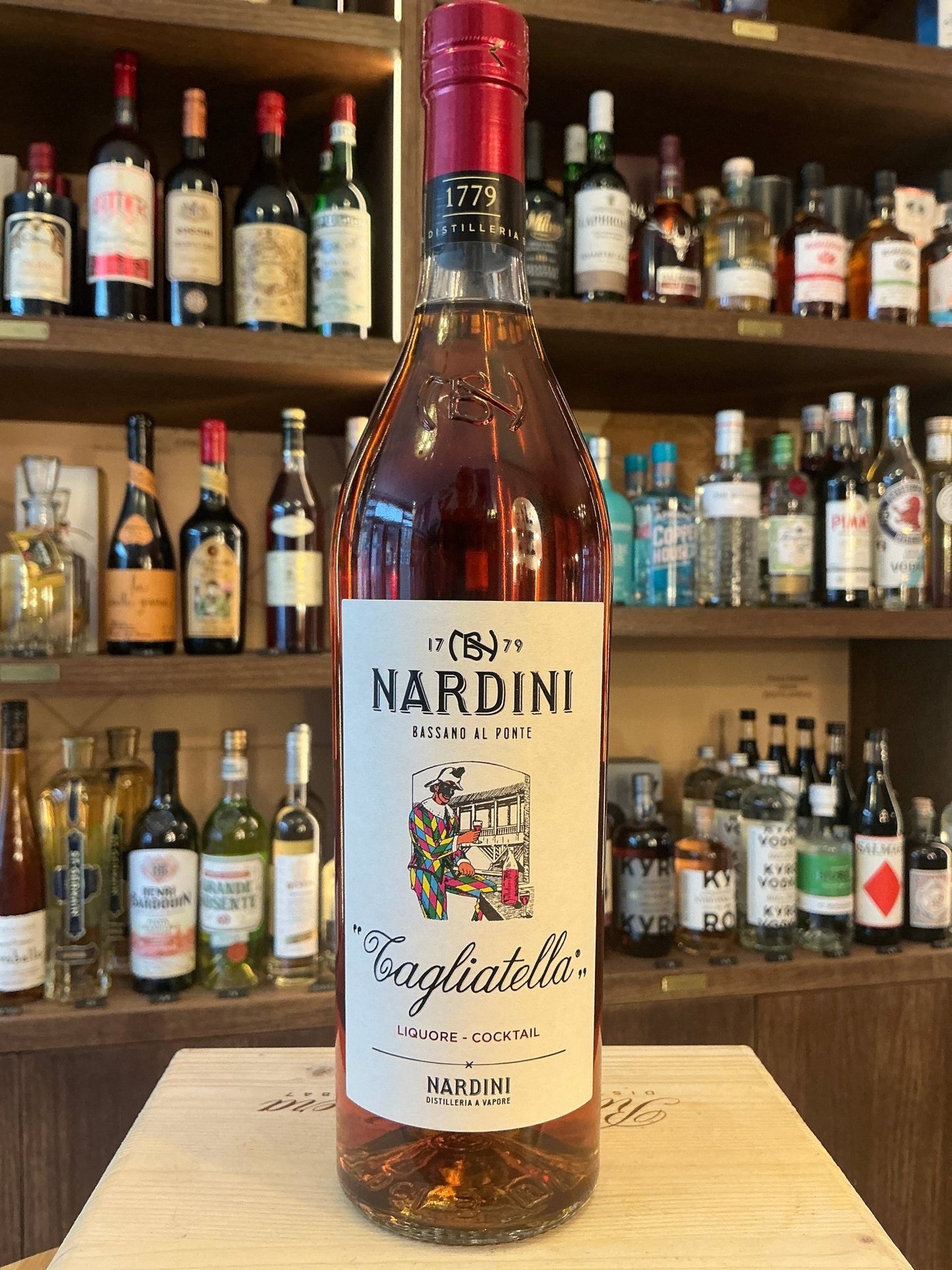 Nardini Tagliatella Italian herbal liqueur bottle with botanical and spiced notes on wooden bar background.