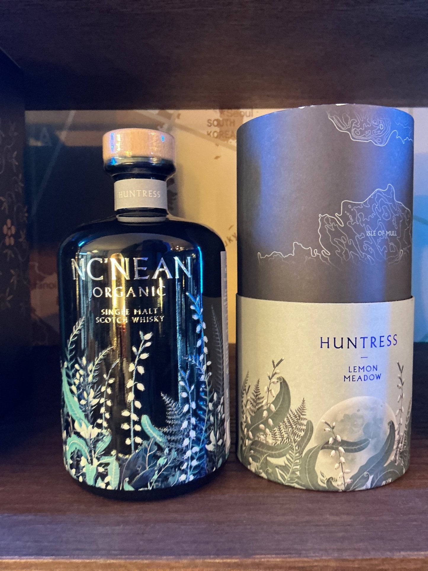 Nc'Nean Whiskey Huntress 2025 Lemon Meadow premium single malt whisky bottle with botanical design and matching cylindrical.