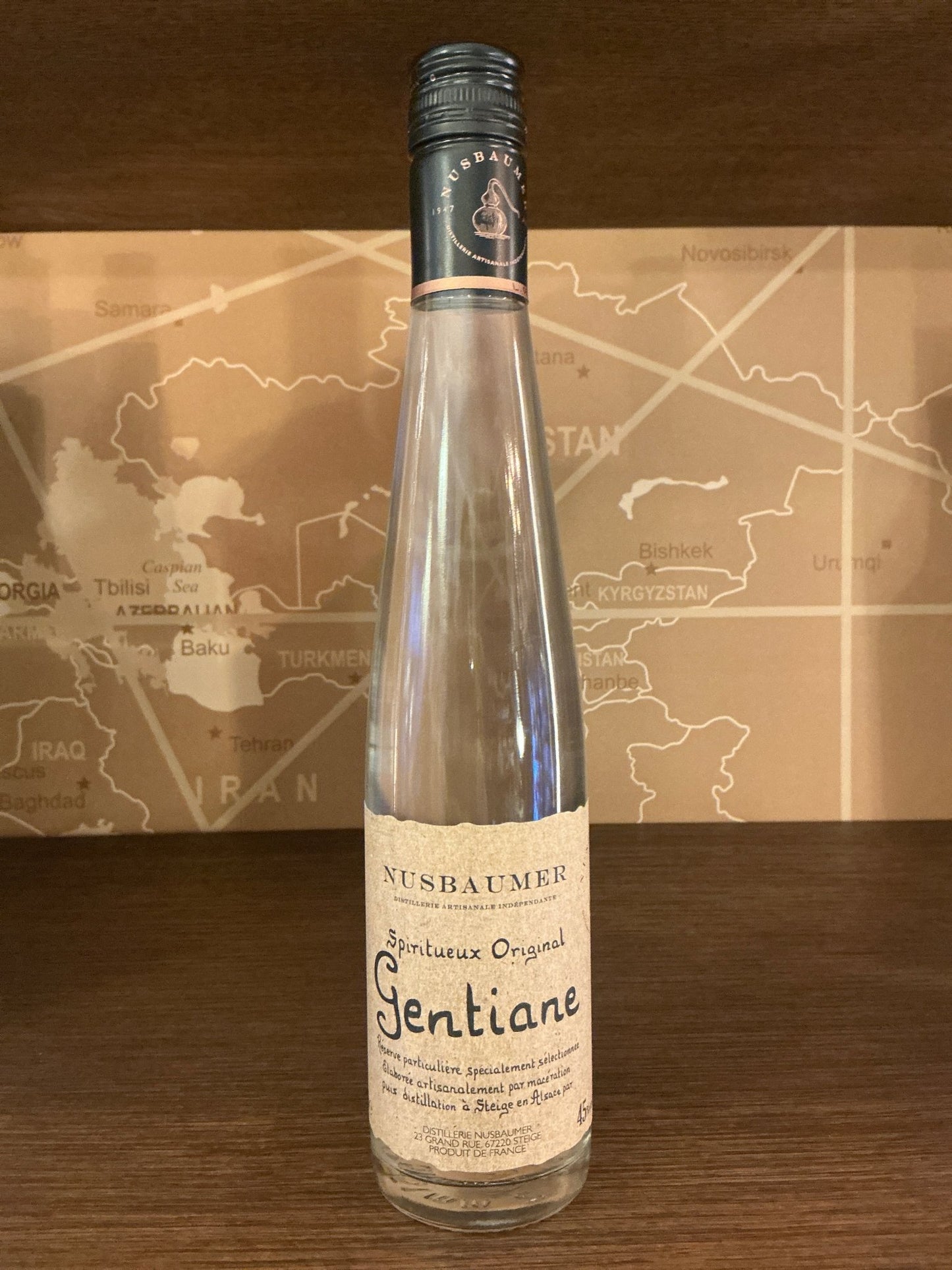 Tall, slender bottle of Nusbaumer Gentiane Liqueur 35cl with artisanal cream label and dark cap, premium Dutch herbal spirit.