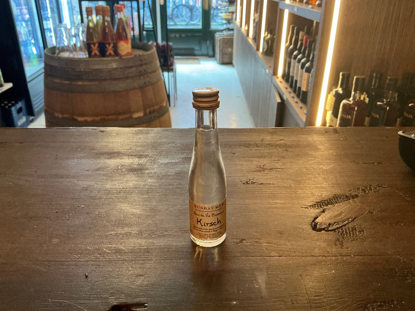 Nusbaumer Vieux Kirsch mini bottle with clear cherry brandy, artisan distilled, premium small batch specialty spirit, wooden .