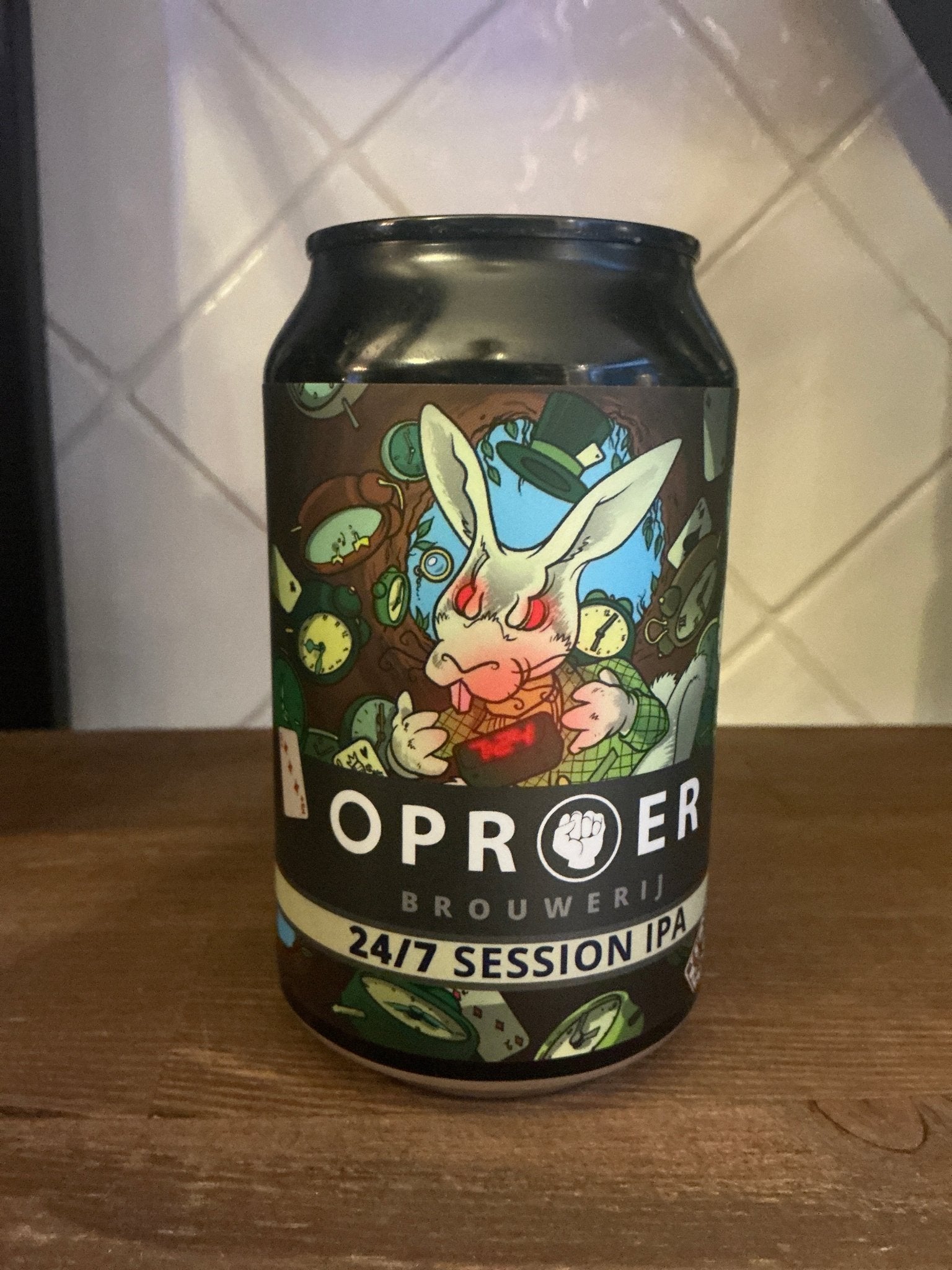 Black can of Oproer 24/7 Session IPA with colorful artisanal illustration of a white rabbit wearing a blue hat surrounded by .