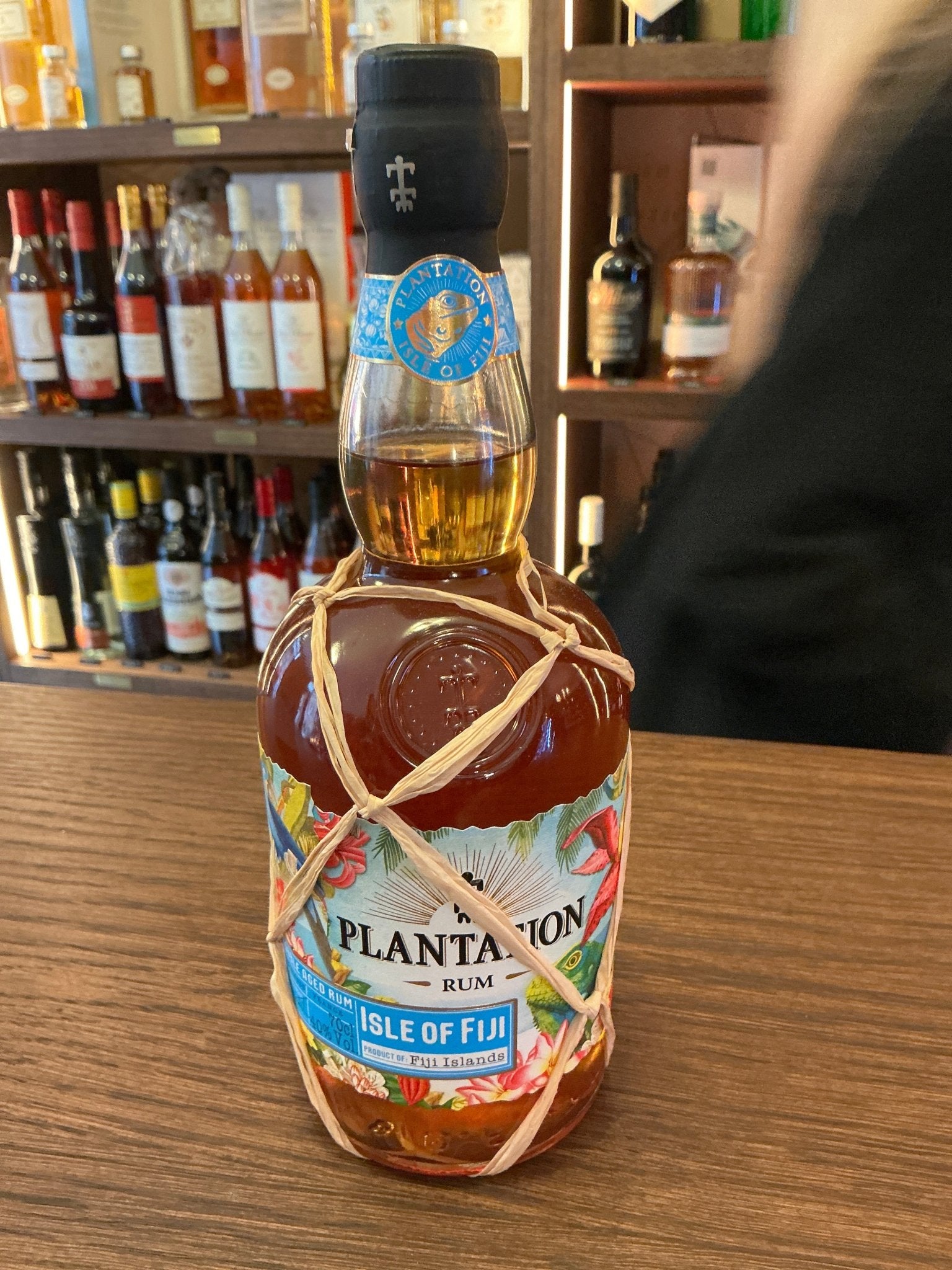 Plantation Isle of Fiji Rum bottle with amber liquid, blue and white label, artisan small batch aged rum with botanical and.