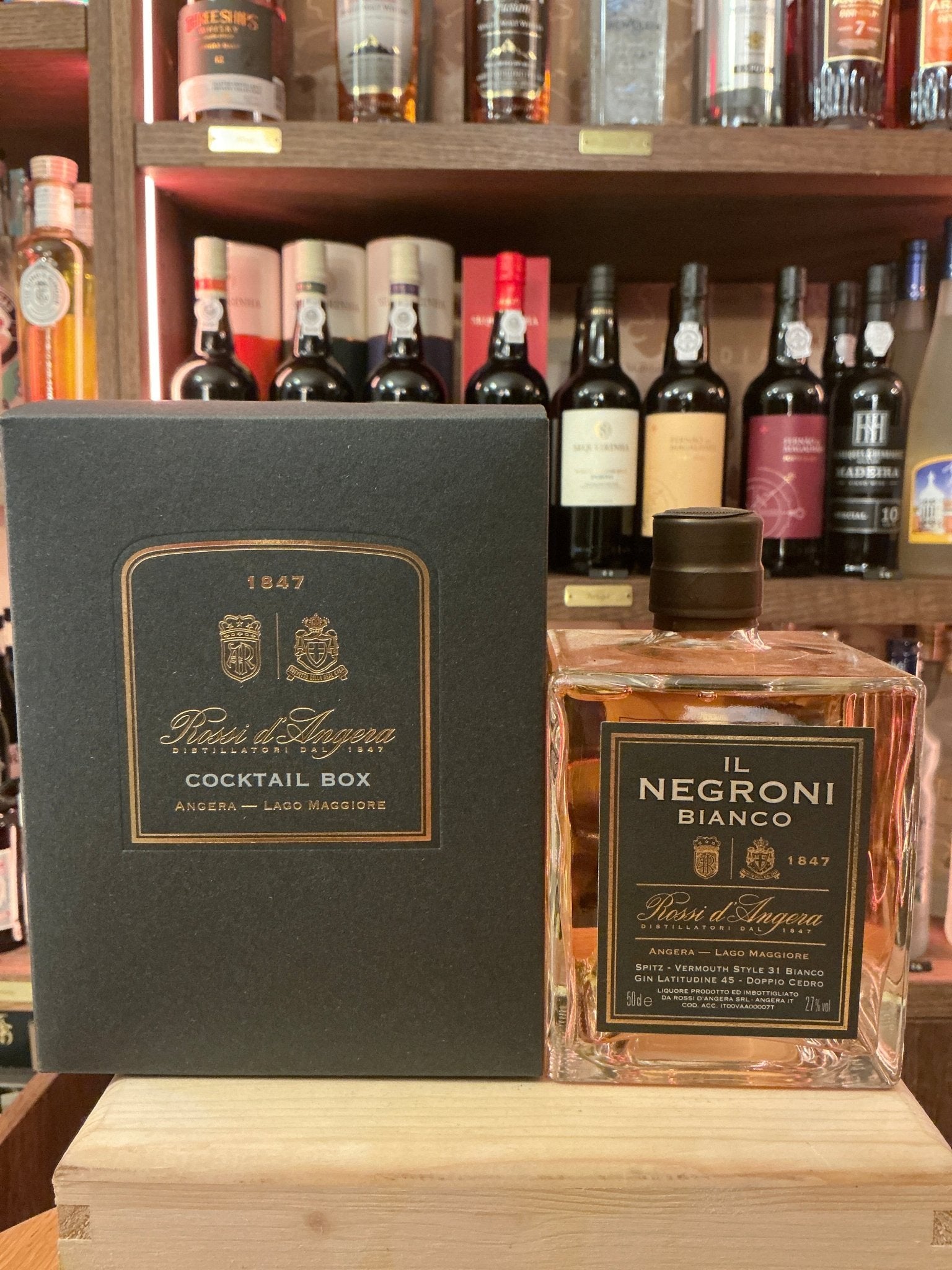 Rossi D'Angera Negroni Bianco pre-mixed cocktail bottle with premium botanical liqueur in clear glass beside elegant black.