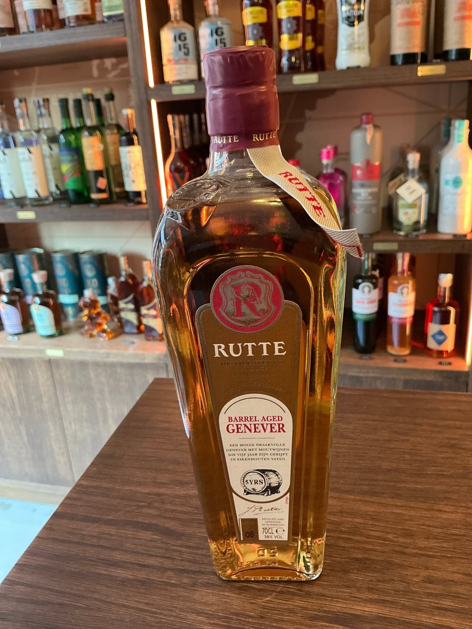 Rutte Barrel Aged Genever bottle with amber liquid, red cap, and artisan Dutch premium aged distilled botanical spirit label .