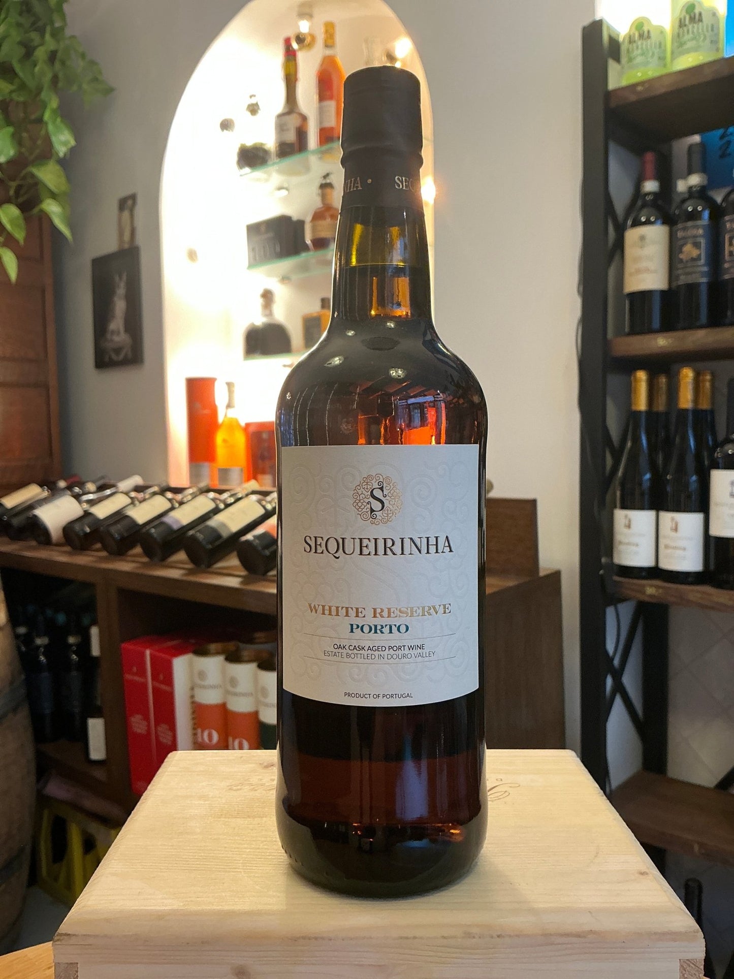 Sequeirinha White Reserve Port bottle with amber liquid, premium artisan fortified wine, small batch specialty spirits,.