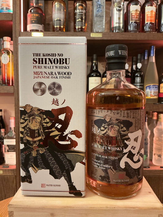 Bottle of Shinobu Pure Malt Mizunara Japanese whisky with amber liquid and a black cap, featuring detailed samurai artwork.