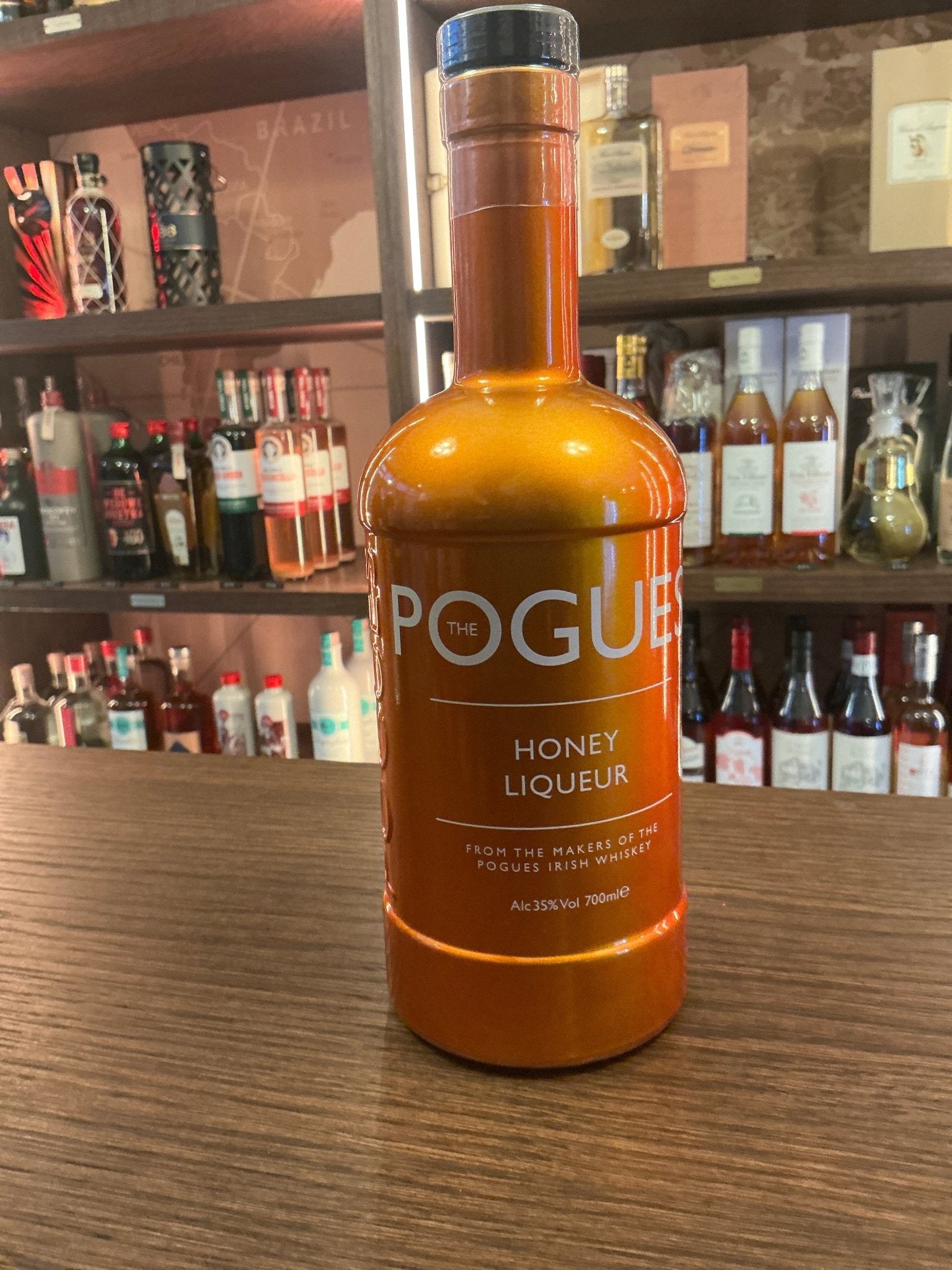 The Pogues Gold Honey Liqueur bottle in amber glass with copper accents, showcasing artisan small-batch premium liqueur.