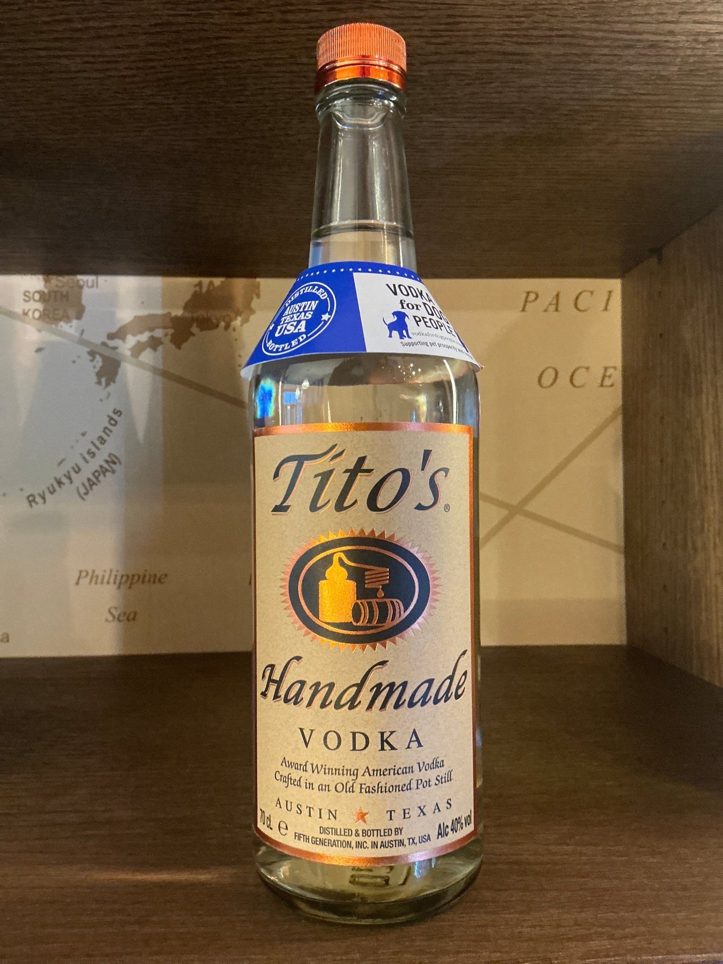 Tito’s Handmade Vodka small batch bottle with orange cap and cream label highlighting premium distilled vodka from Texas.