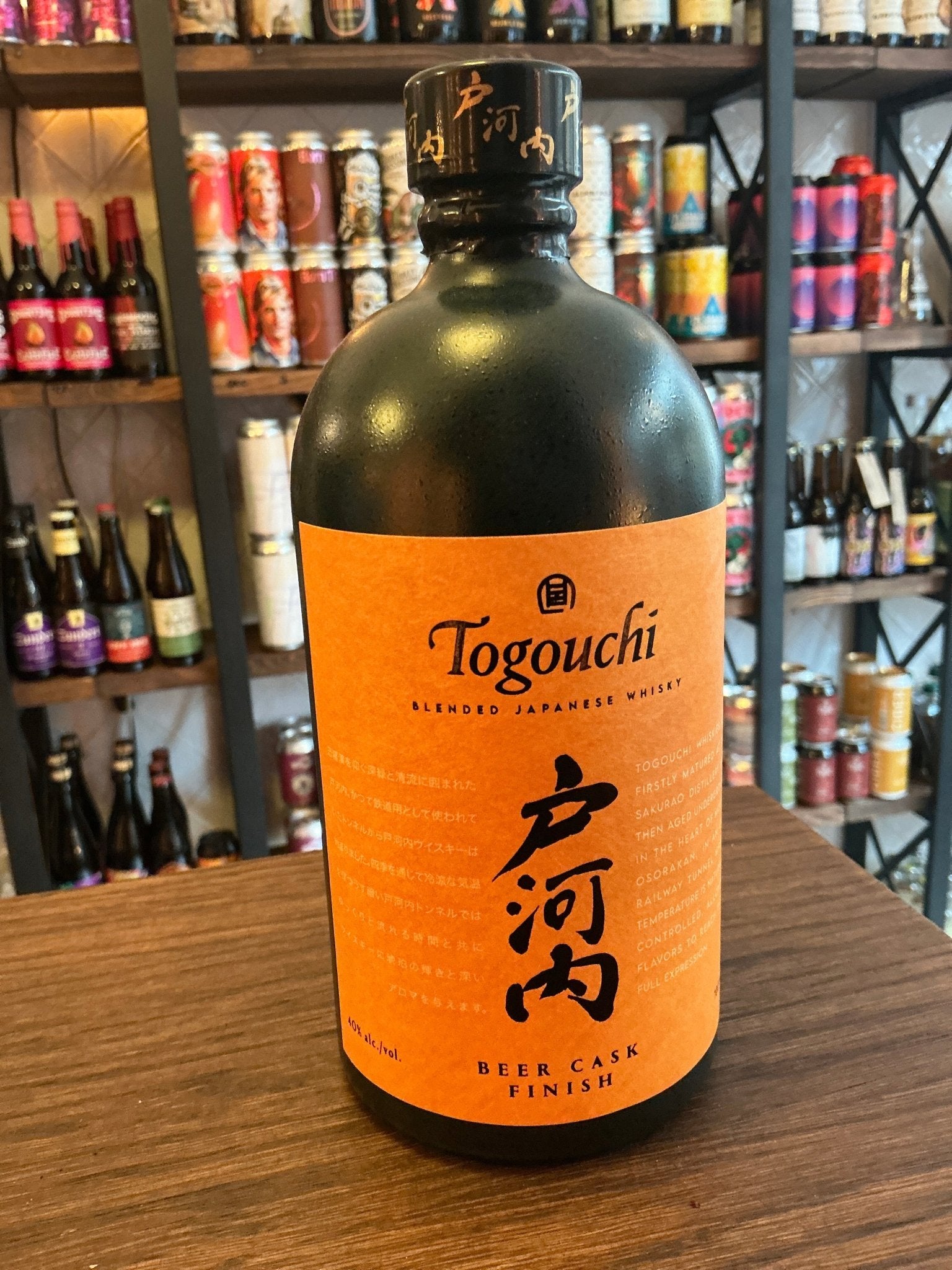 Matte black bottle of Togouchi Beer Cask Finish Japanese whisky with orange label featuring bold black calligraphy and.
