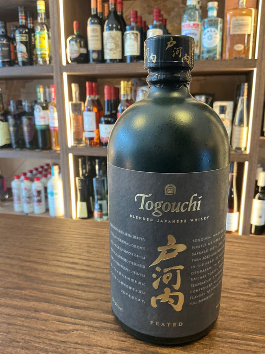 Matte black bottle of Togouchi Peated Single Malt Japanese whisky with gold accents, premium small batch artisan spirit on.