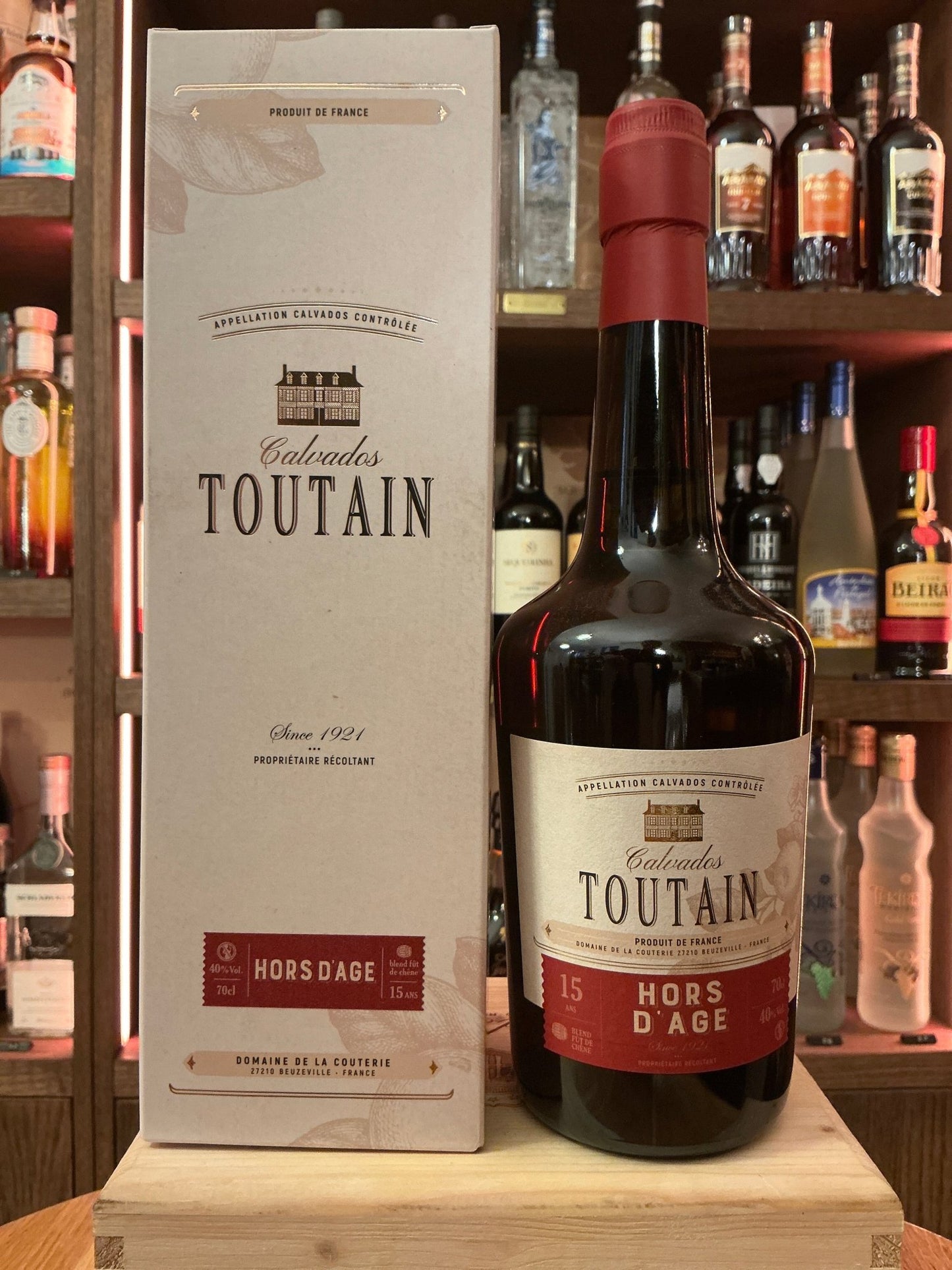 Premium Toutain Calvados Hors d’age brandy bottle with deep amber liquid, artisanal small-batch aged spirit, presented.