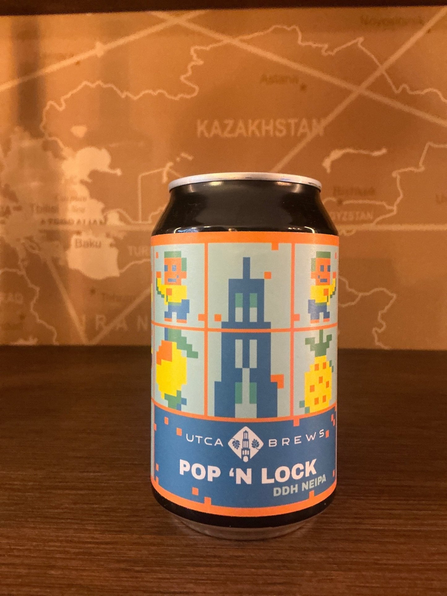 Blue aluminum can featuring pixel art of a Dutch building and tulips in yellow and orange, labeled UTCA Pop ‘N Lock IPA with