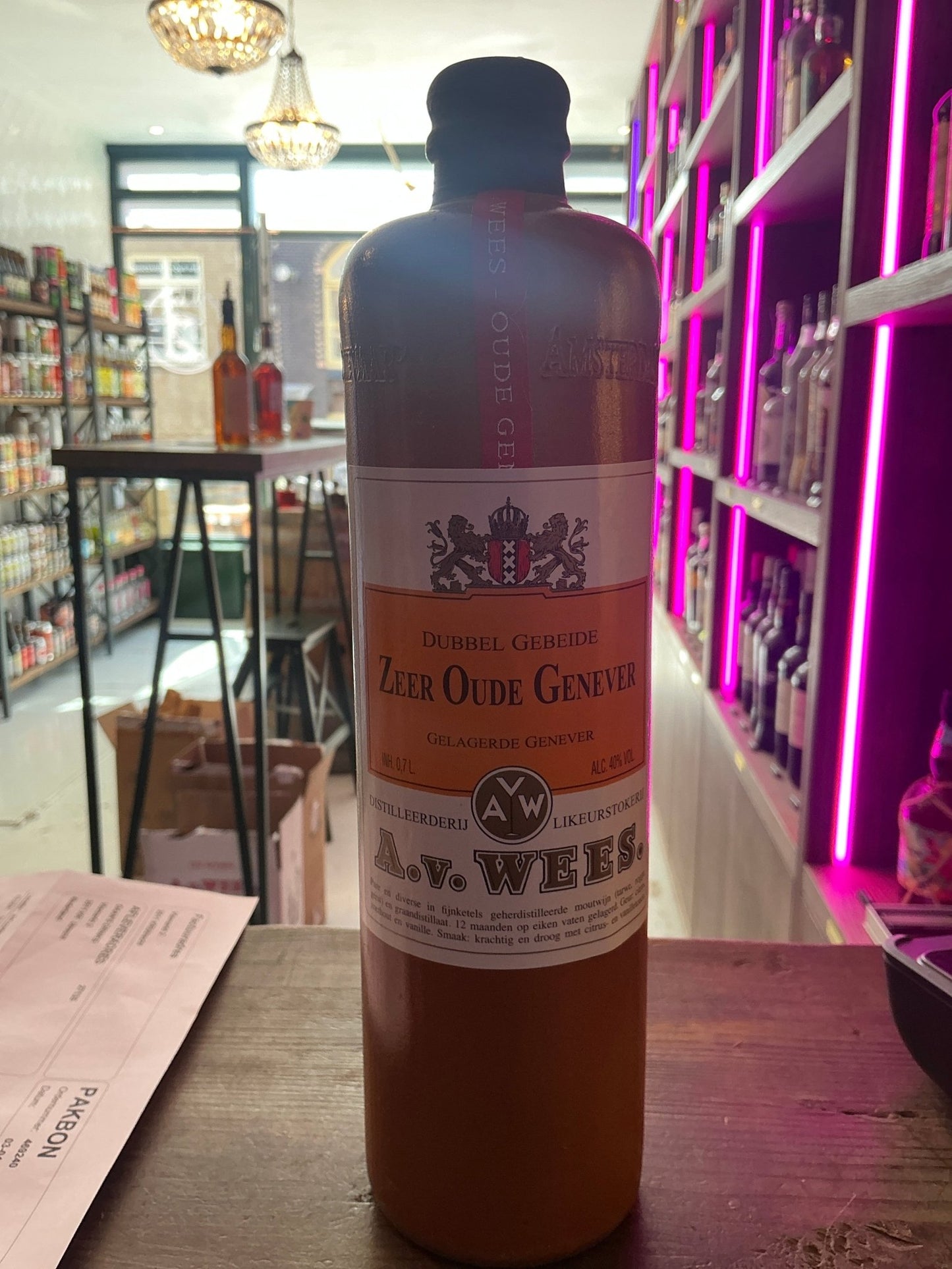 Tall amber bottle of Van Wees Zeer Oude Genever with cream label and black cap, premium aged Dutch gin-like spirit displayed .