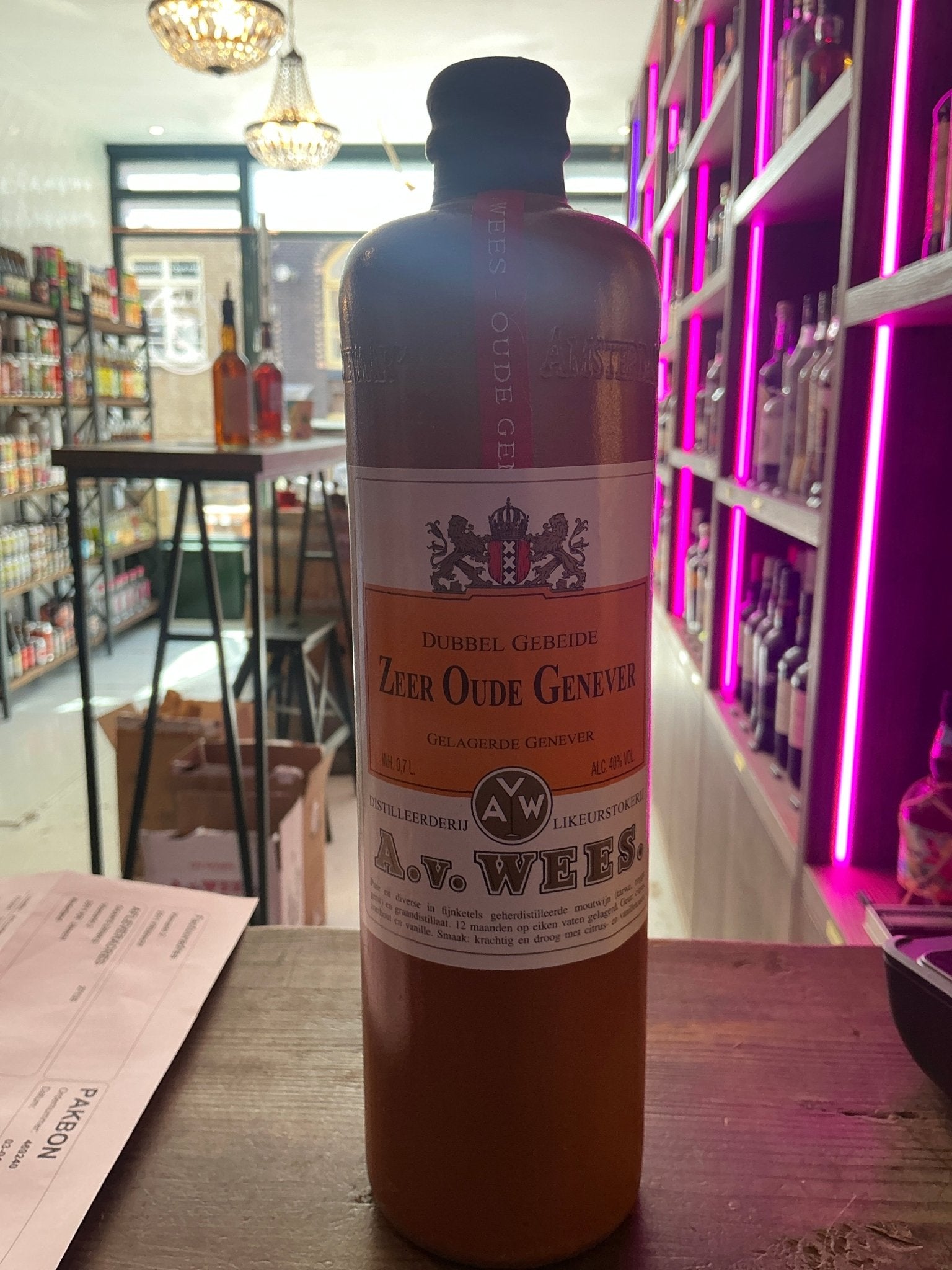 Tall amber bottle of Van Wees Zeer Oude Genever with cream label and black cap, premium aged Dutch gin-like spirit displayed .