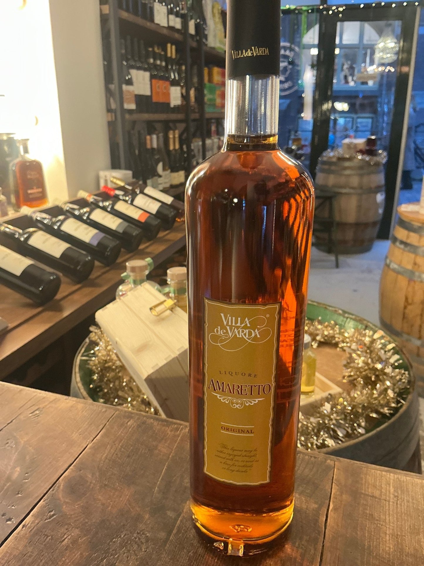 Villa de Varda Amaretto bottle with amber liqueur, premium artisan Italian specialty spirit, botanical and spiced flavor.