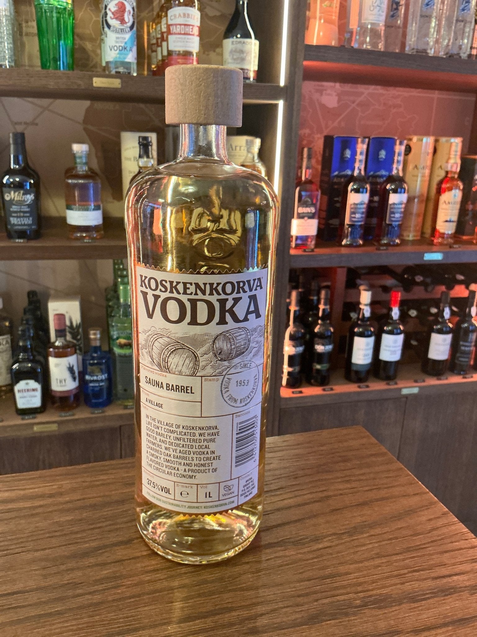 Koskenkorva vodka in tall clear glass bottle with cork stopper and natural fiber collar, premium Finnish distilled vodka on.