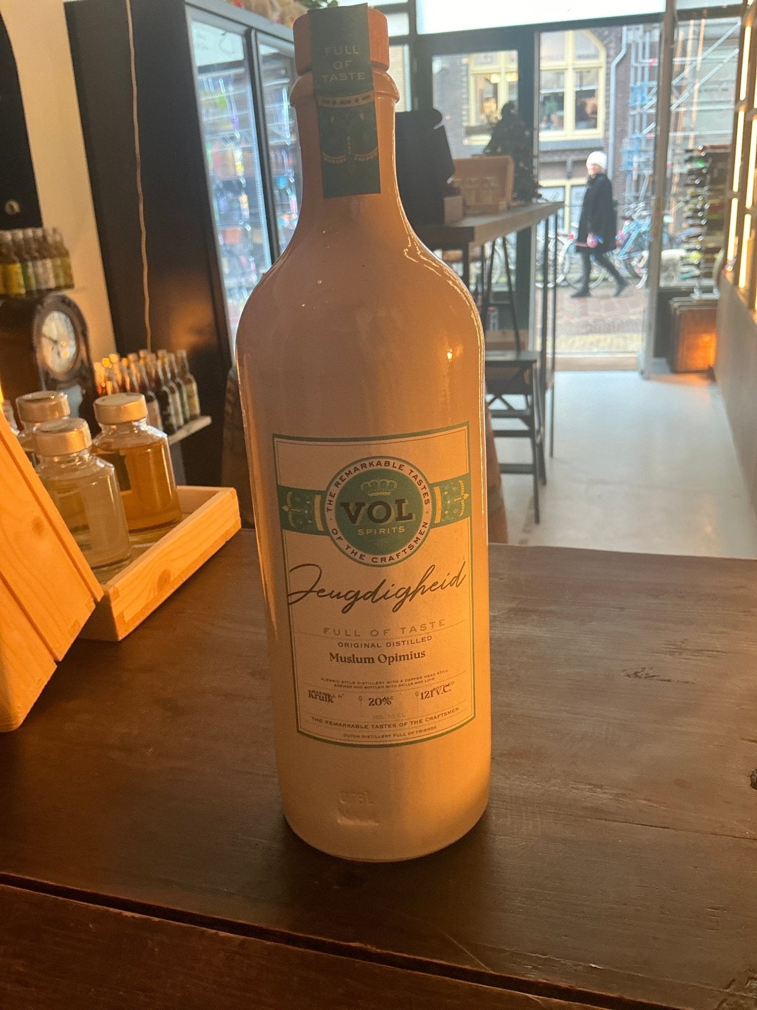 Tall white ceramic bottle of VOL-SPIRITS Jeugdigheid gin, labeled with green and black print, artisan Dutch premium.