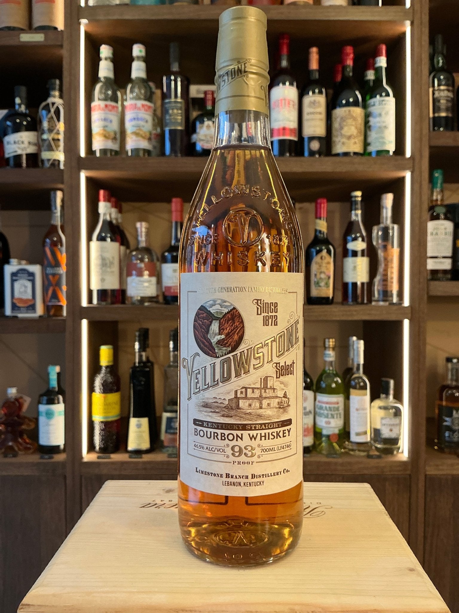 Yellowstone Bourbon bottle with amber aged bourbon, small batch, premium distilled Kentucky bourbon on wooden surface,.