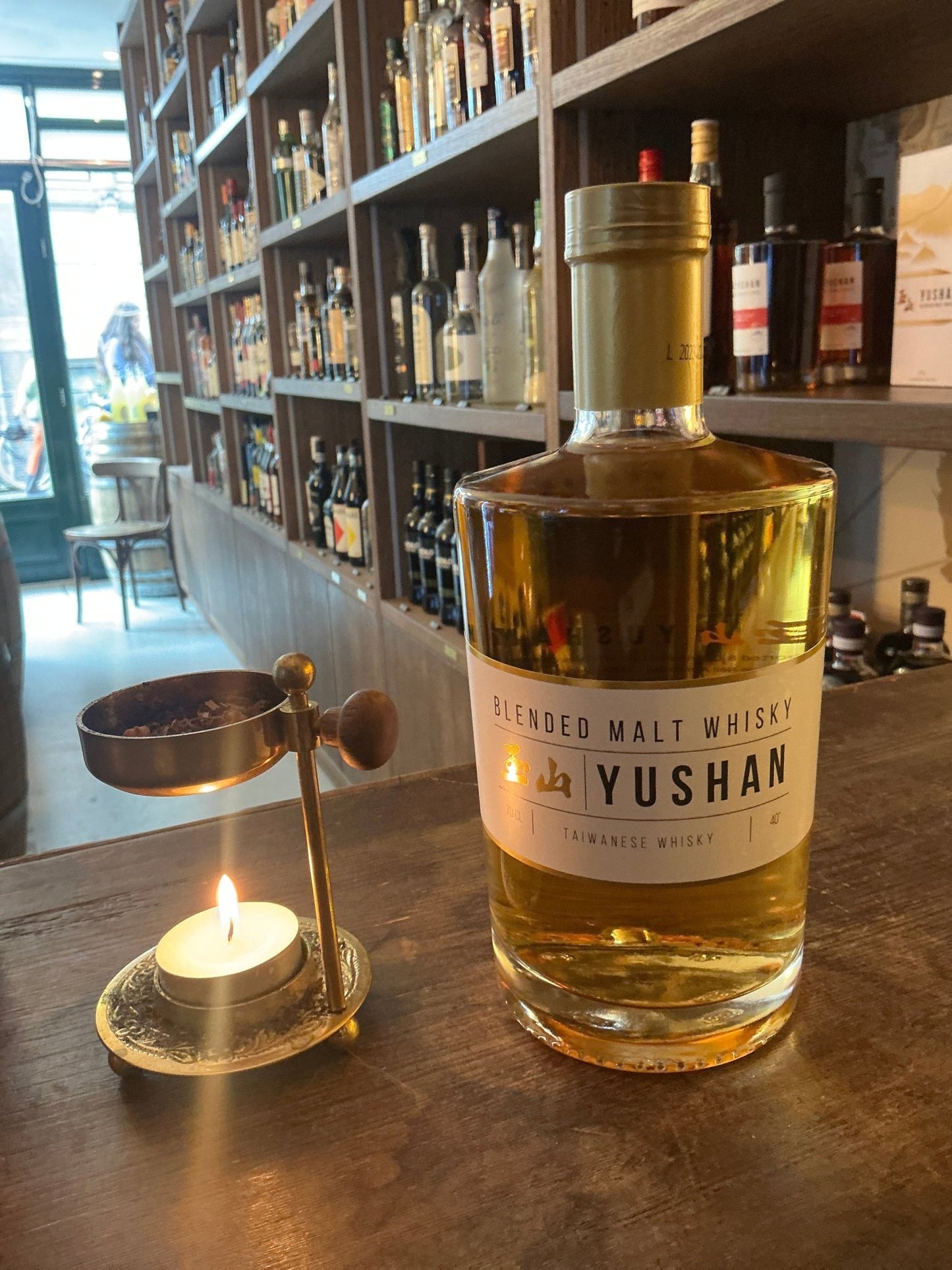 Yushan Blended Malt whisky bottle, premium aged Taiwanese craft spirit with distilled botanical notes, displayed on wooden.